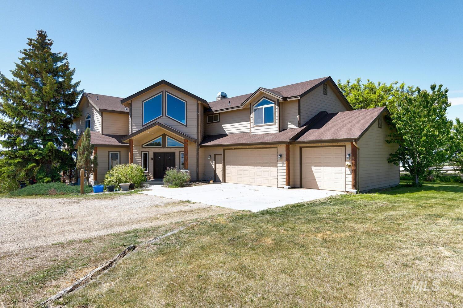 View of front of house featuring driveway, an attached garage, a front lawn, and roof with shingles