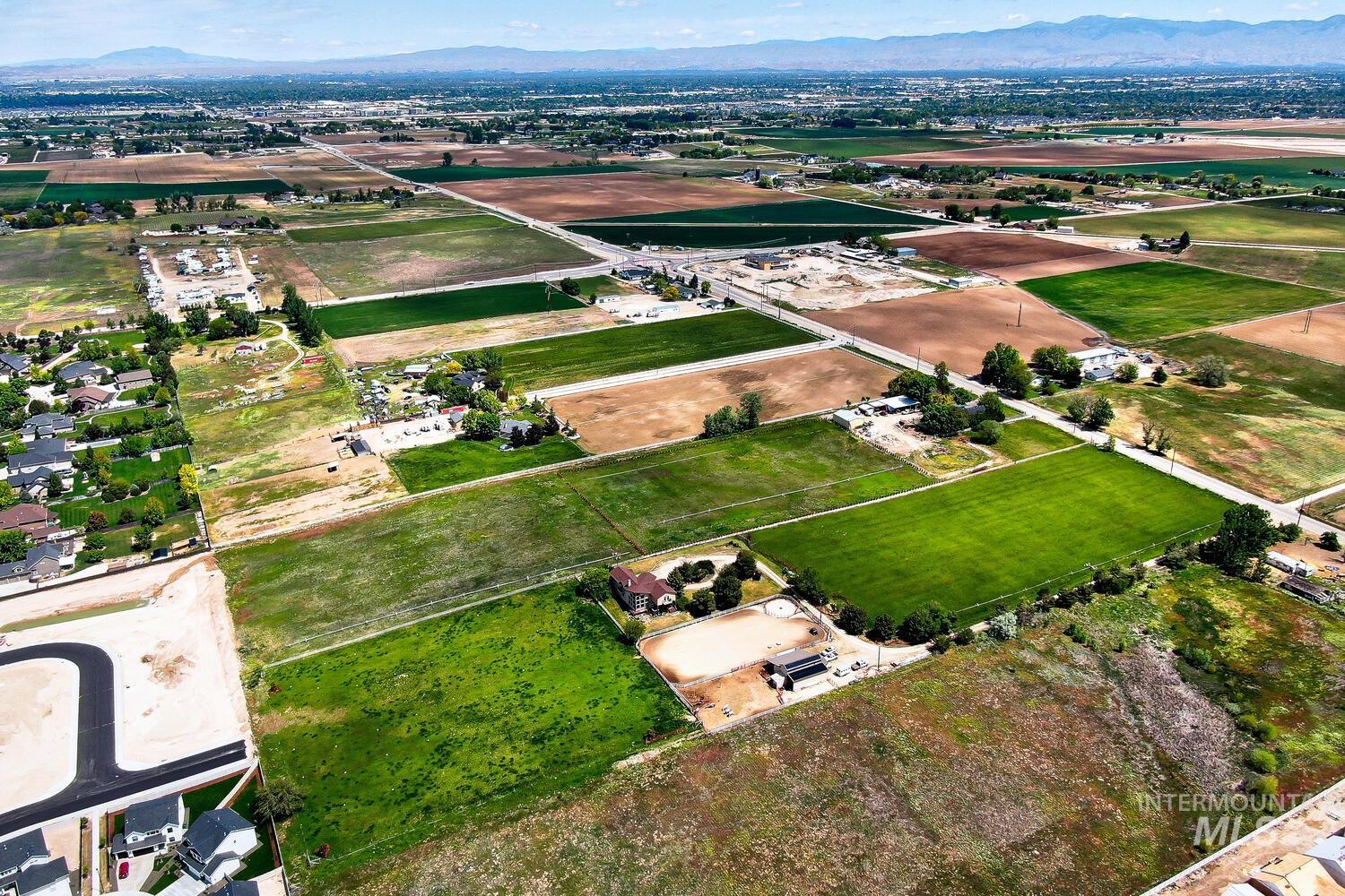 Aerial view of property and surrounding area with a mountain backdrop