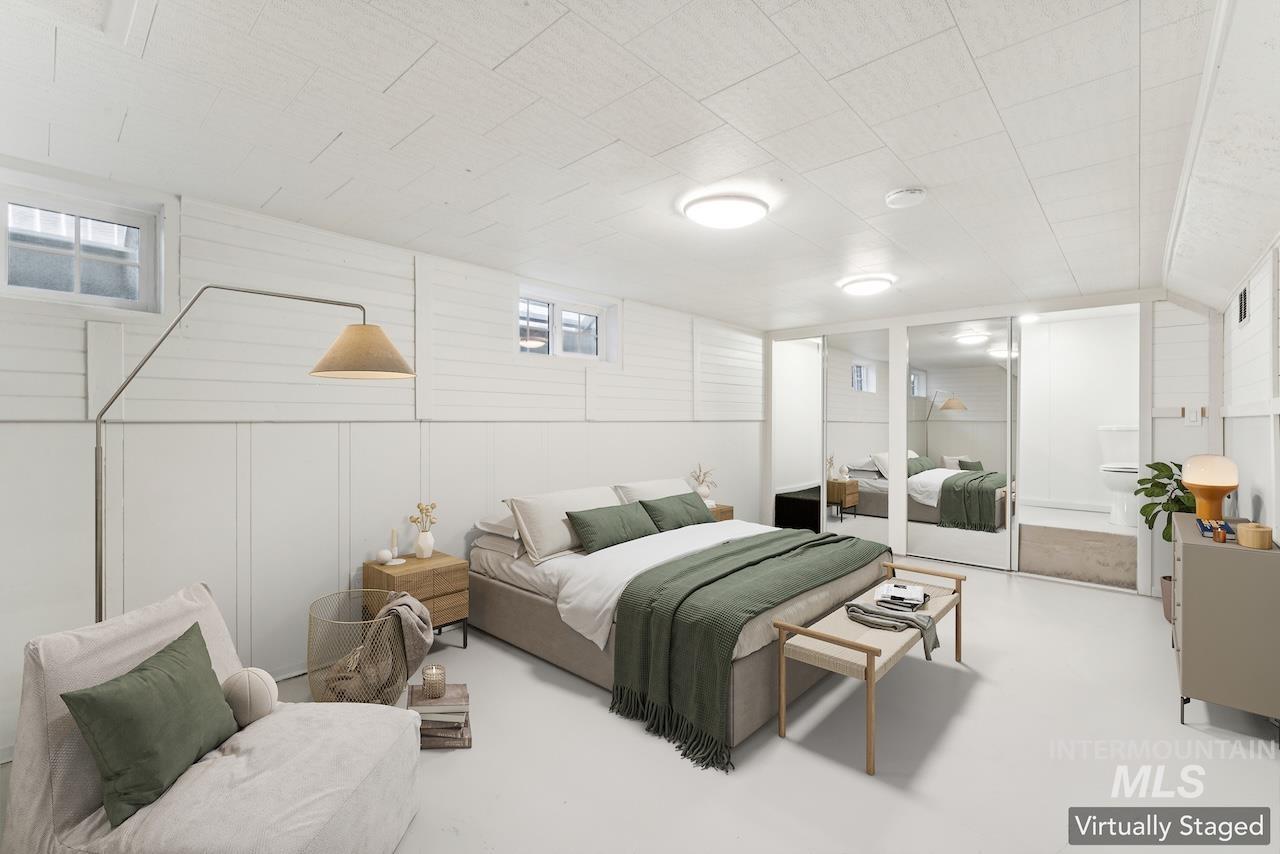 Bedroom with wooden walls, a decorative wall, and finished concrete flooring