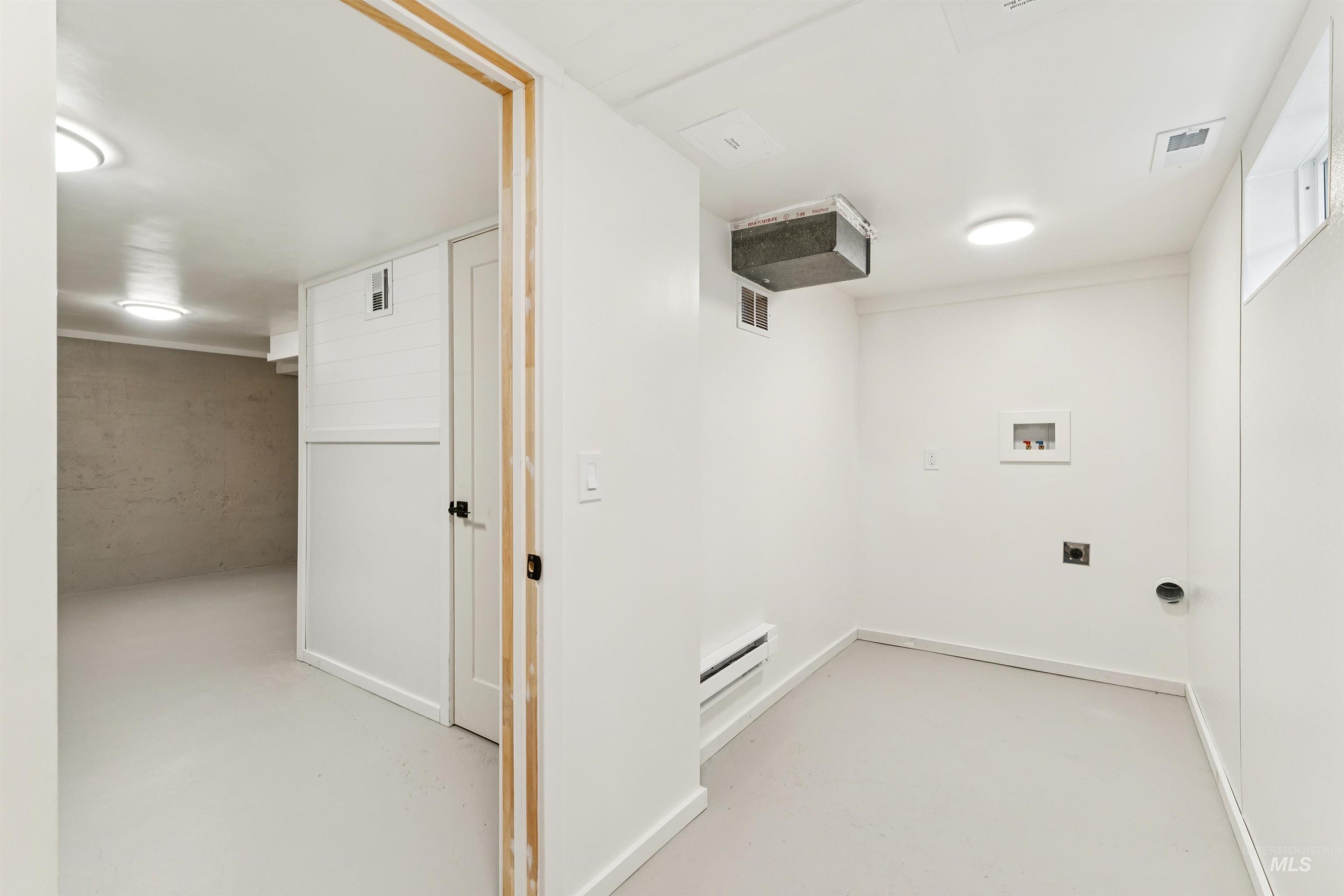Laundry room with hookup for a washing machine, a baseboard heating unit, and electric dryer hookup