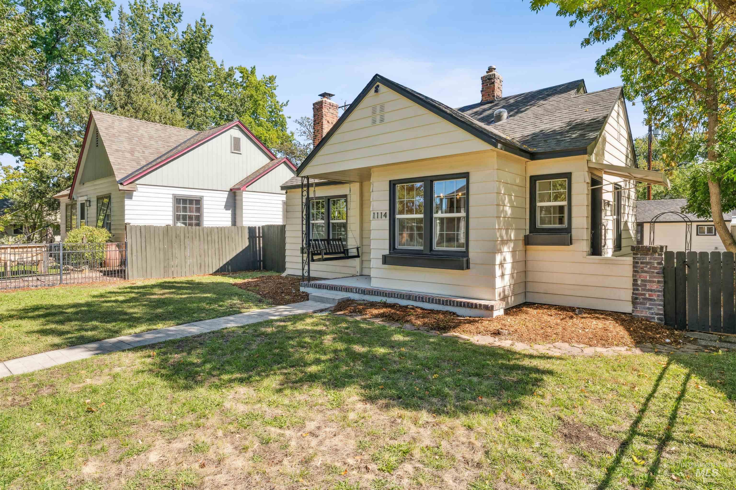 Bungalow-style home featuring roof with shingles and a chimney