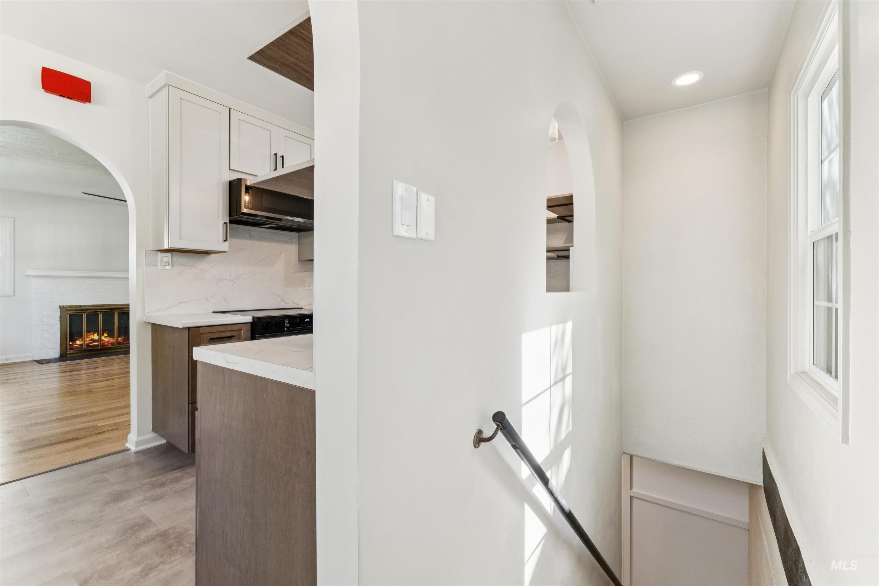 Stairs with arched walkways, a fireplace, and recessed lighting