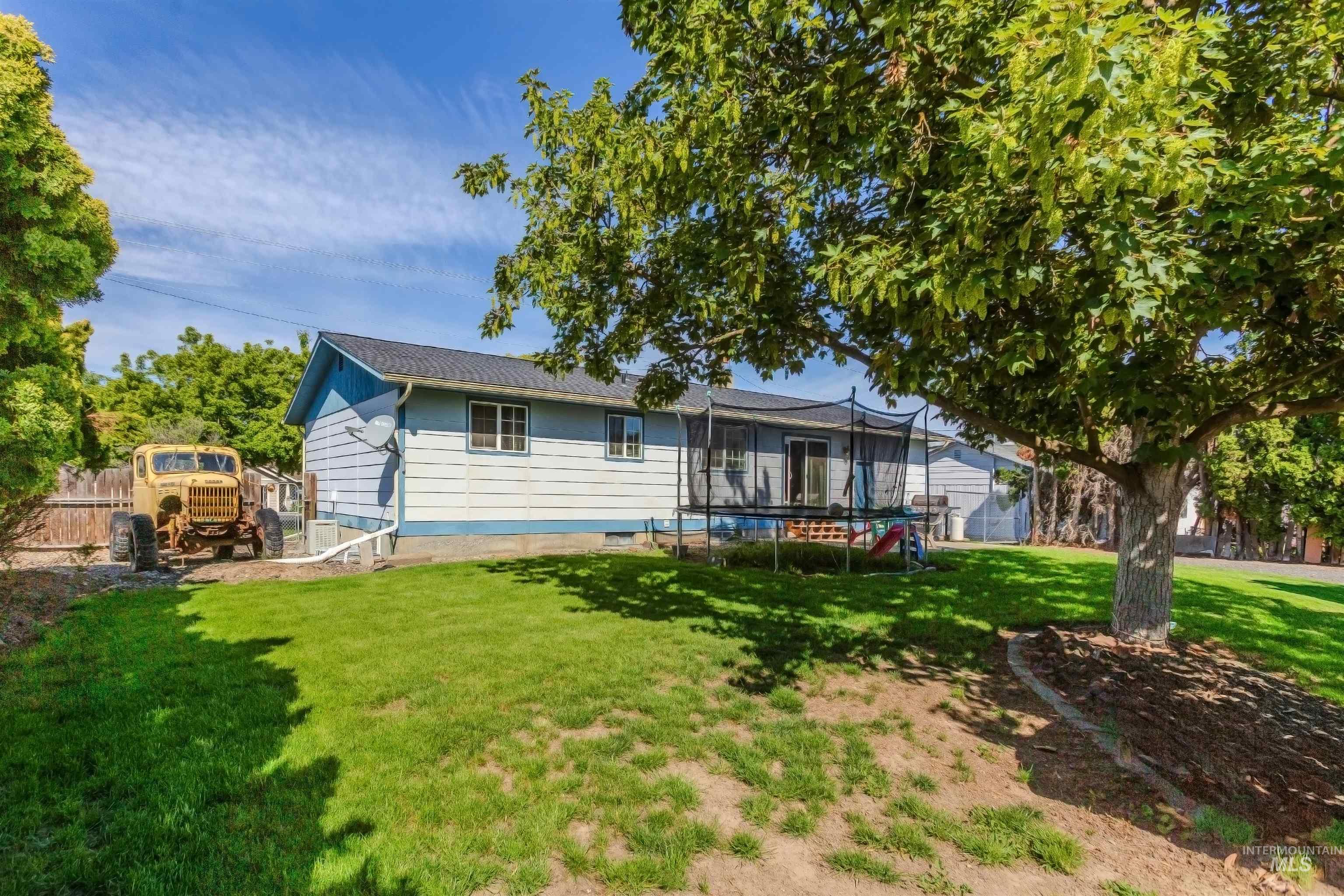 Rear view of property featuring a trampoline and crawl space