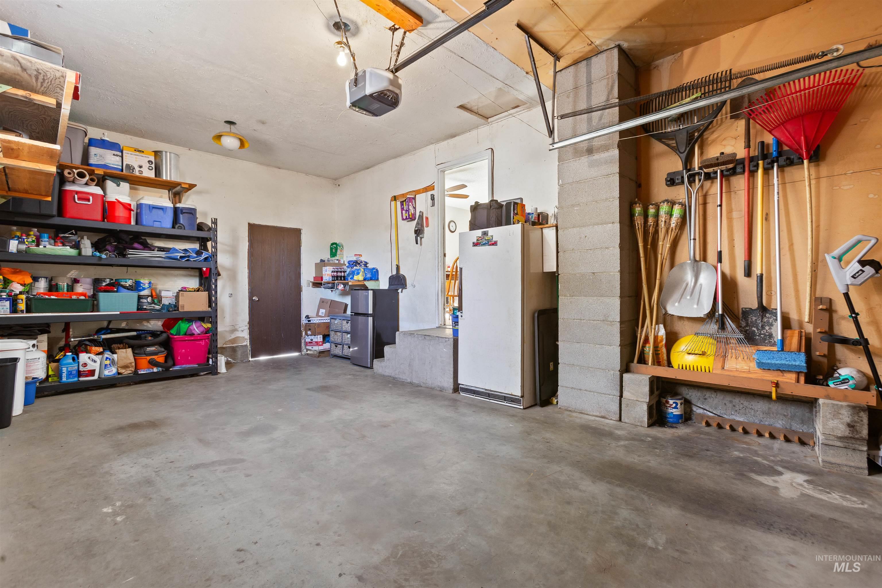 Garage with freestanding refrigerator and a garage door opener