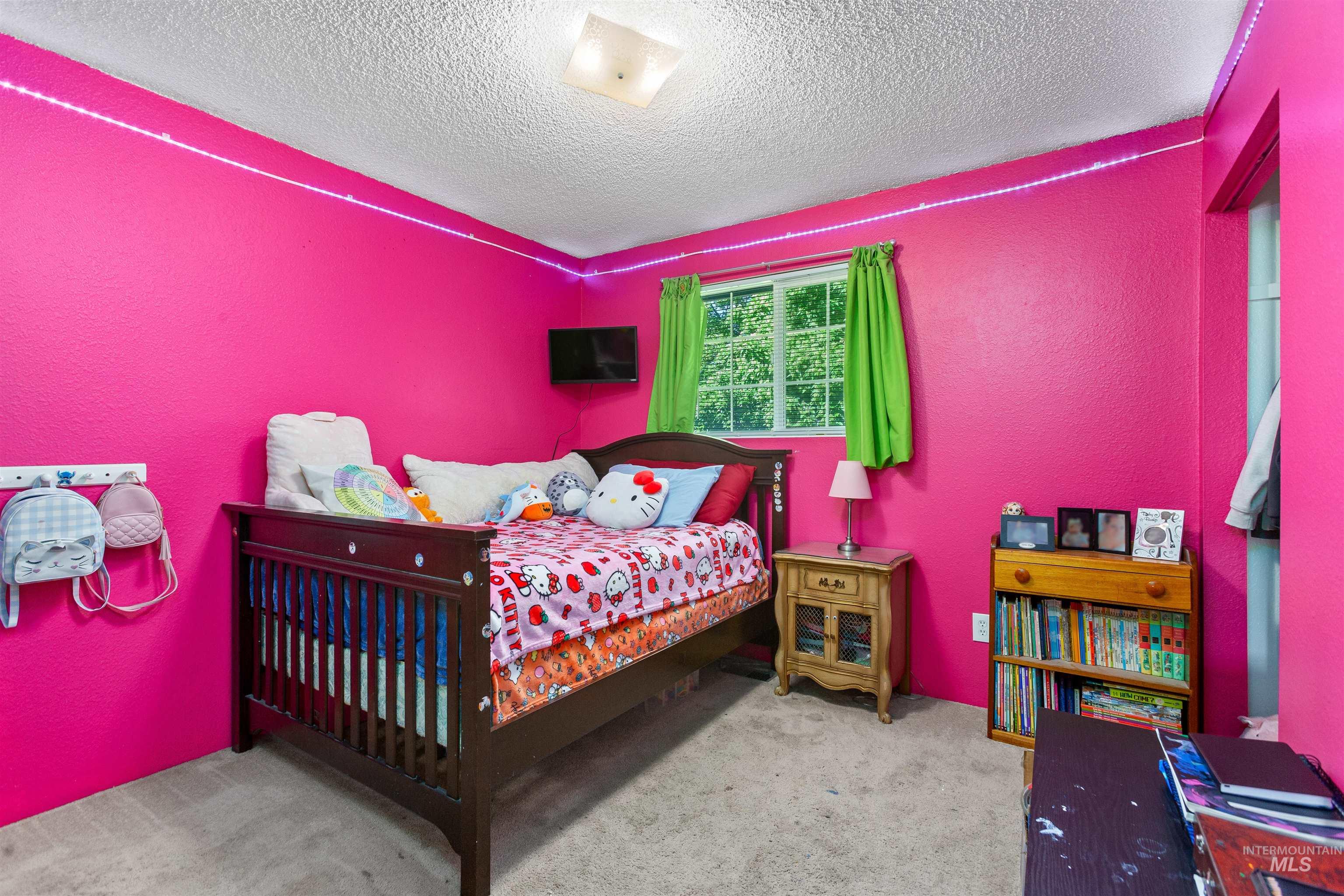 Carpeted bedroom with a textured wall and a textured ceiling