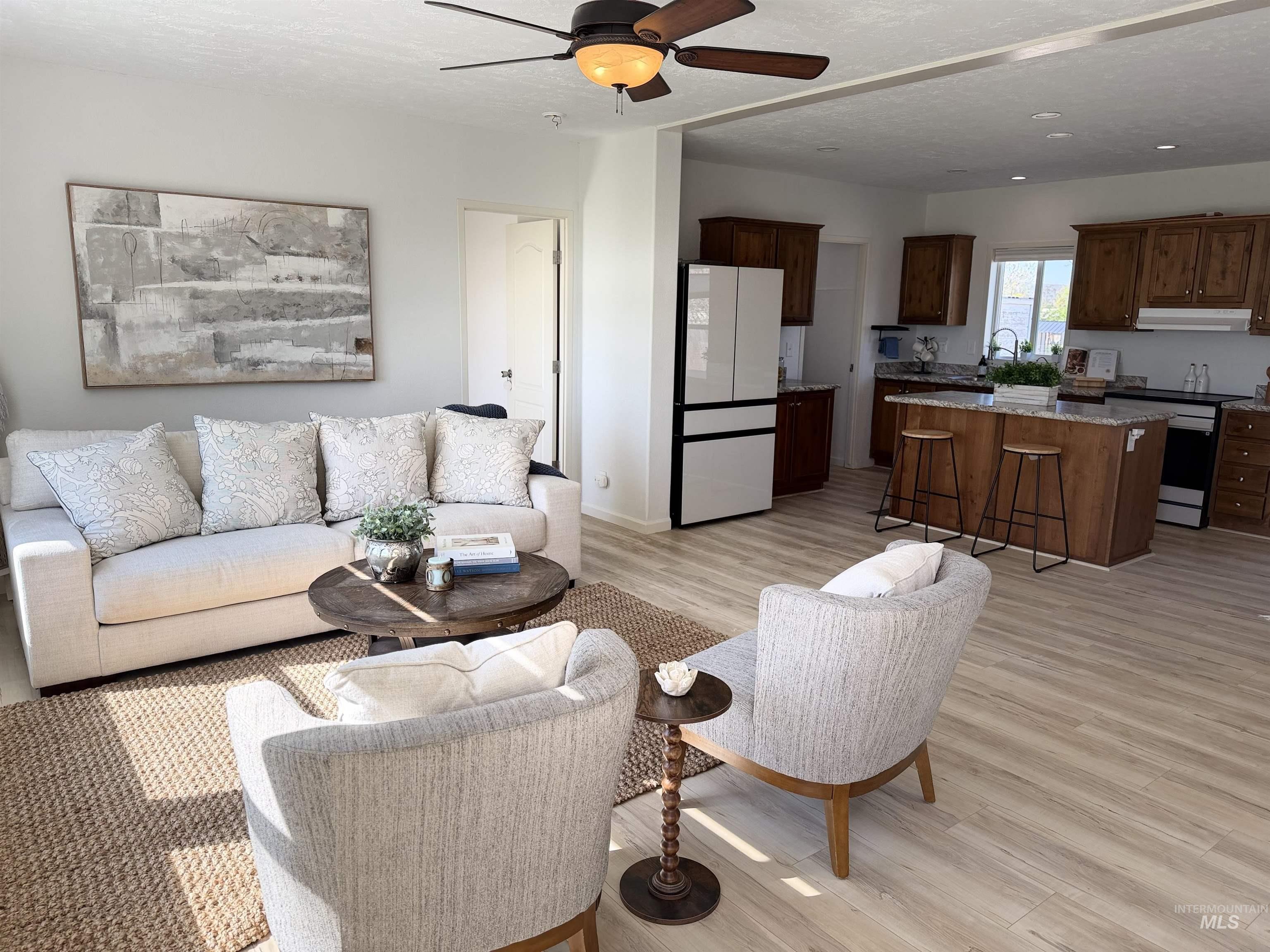 Open concept living area featuring light wood-finish flooring, a ceiling fan, and recessed lighting