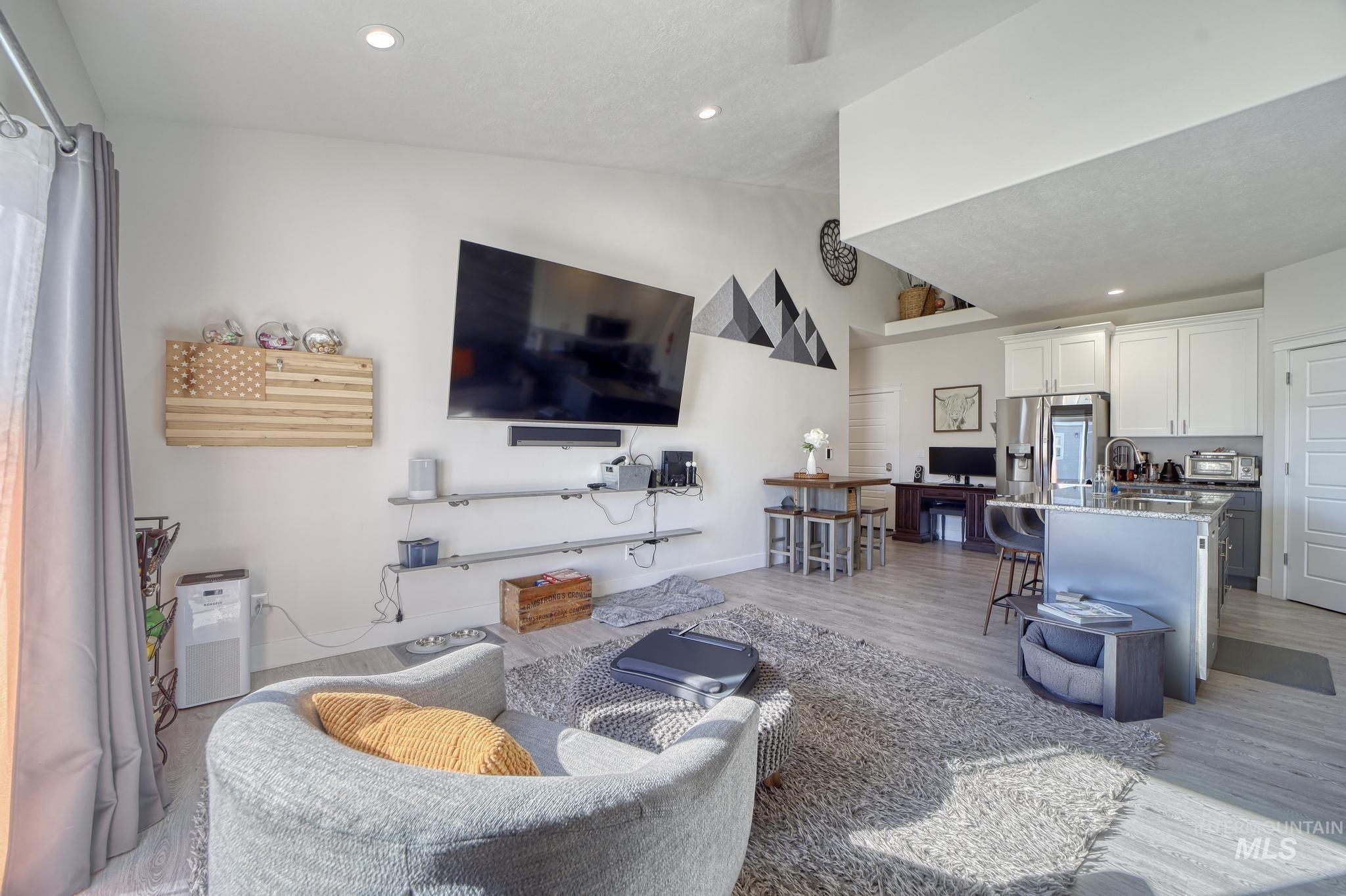 Living room featuring vaulted ceiling, recessed lighting, and light wood-type flooring