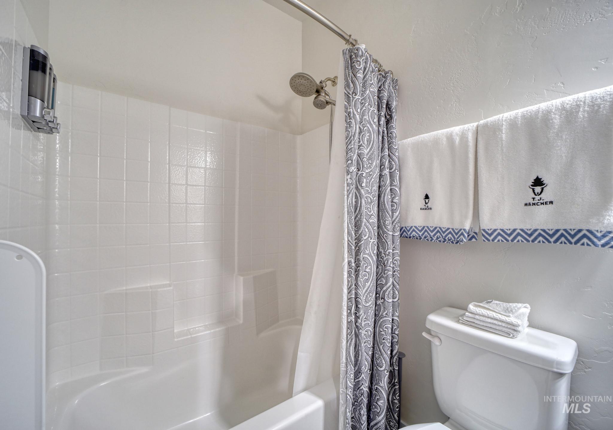 Bathroom featuring shower / bath combo with shower curtain and toilet