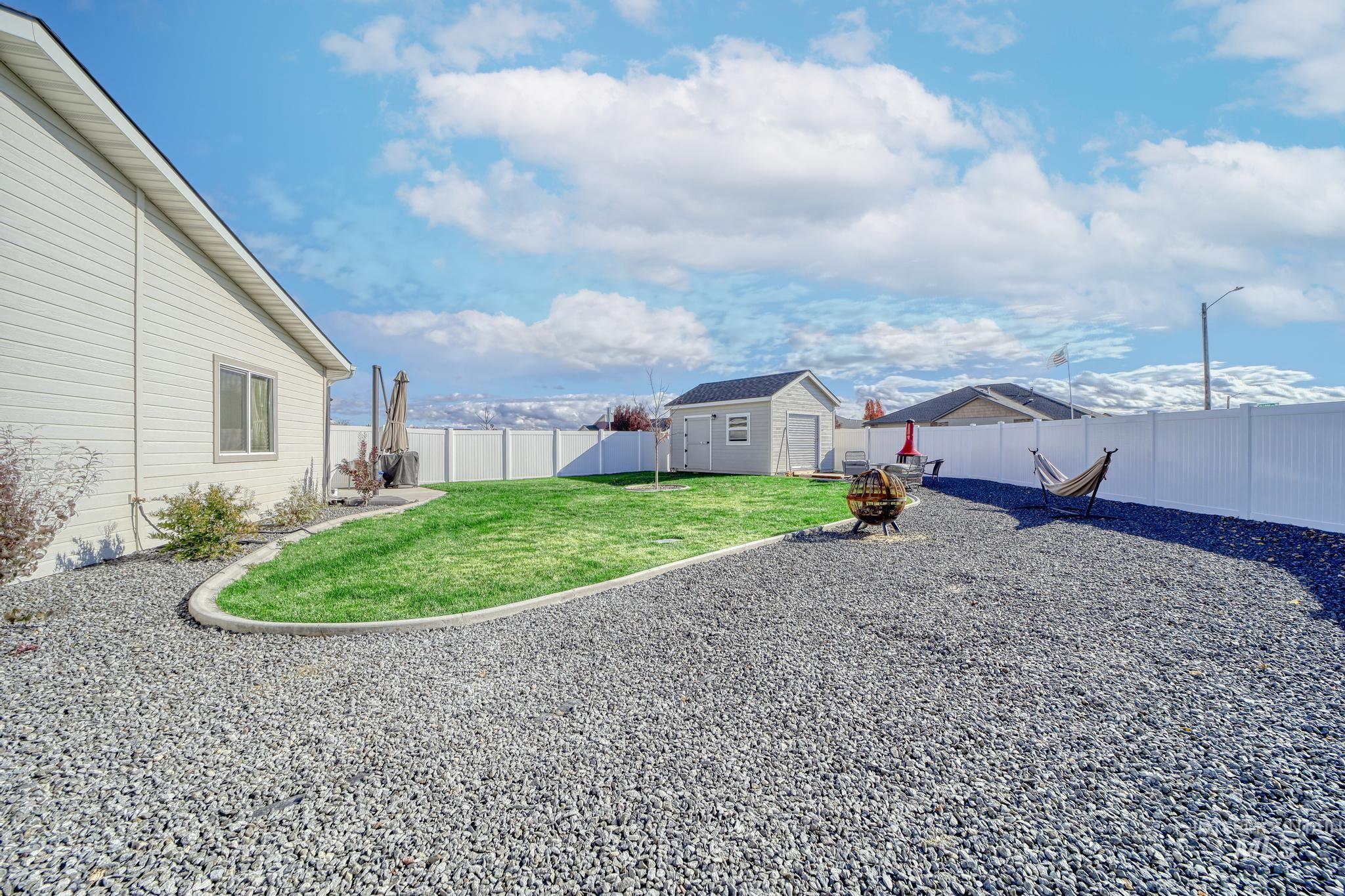 Fenced backyard featuring a shed