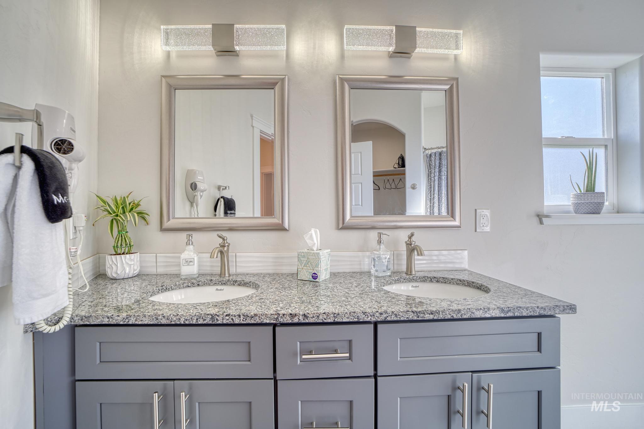 Bathroom featuring double vanity and curtained shower