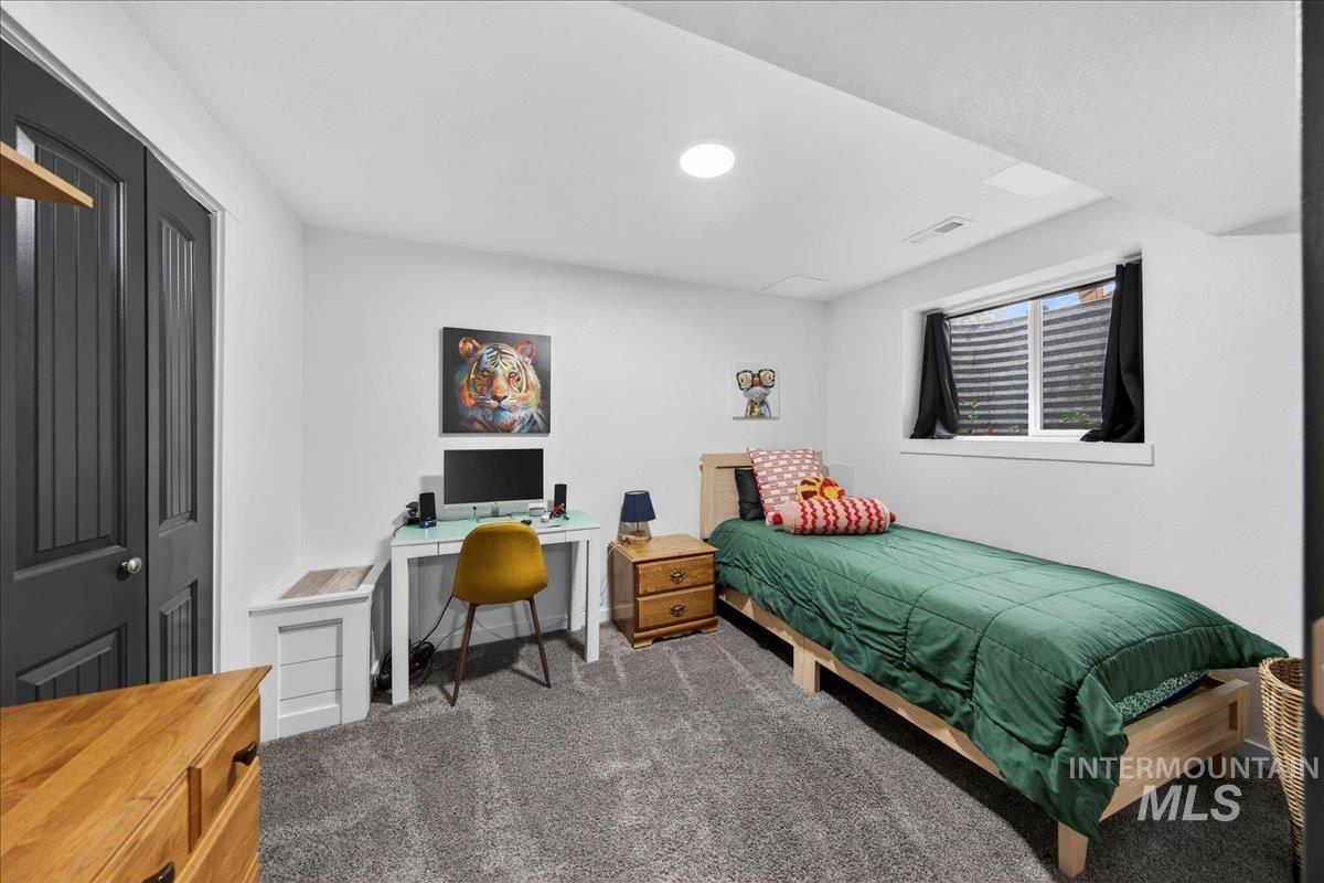 Bedroom featuring dark carpet and an office area