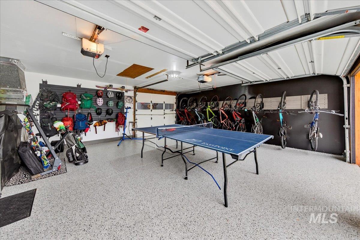 Recreation room featuring speckle patterned floor and a garage