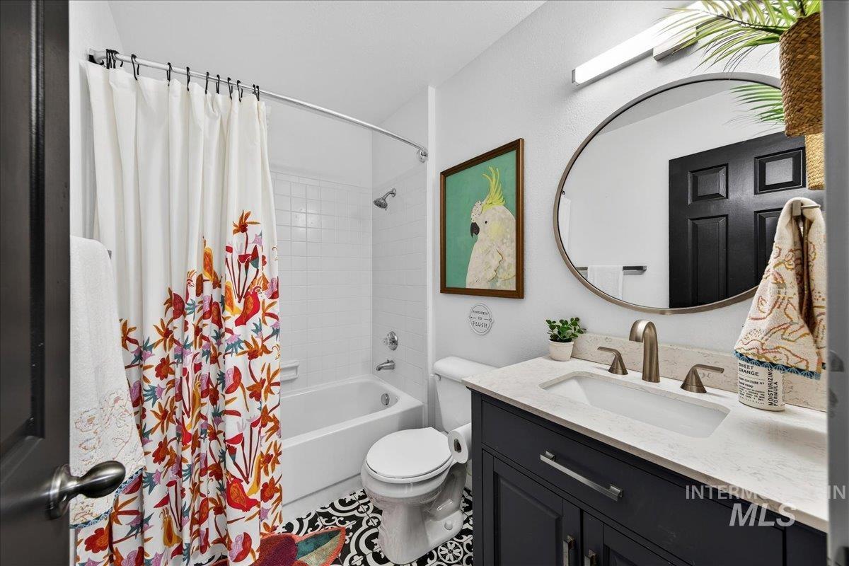 Bathroom with shower / bath combo with shower curtain and vanity