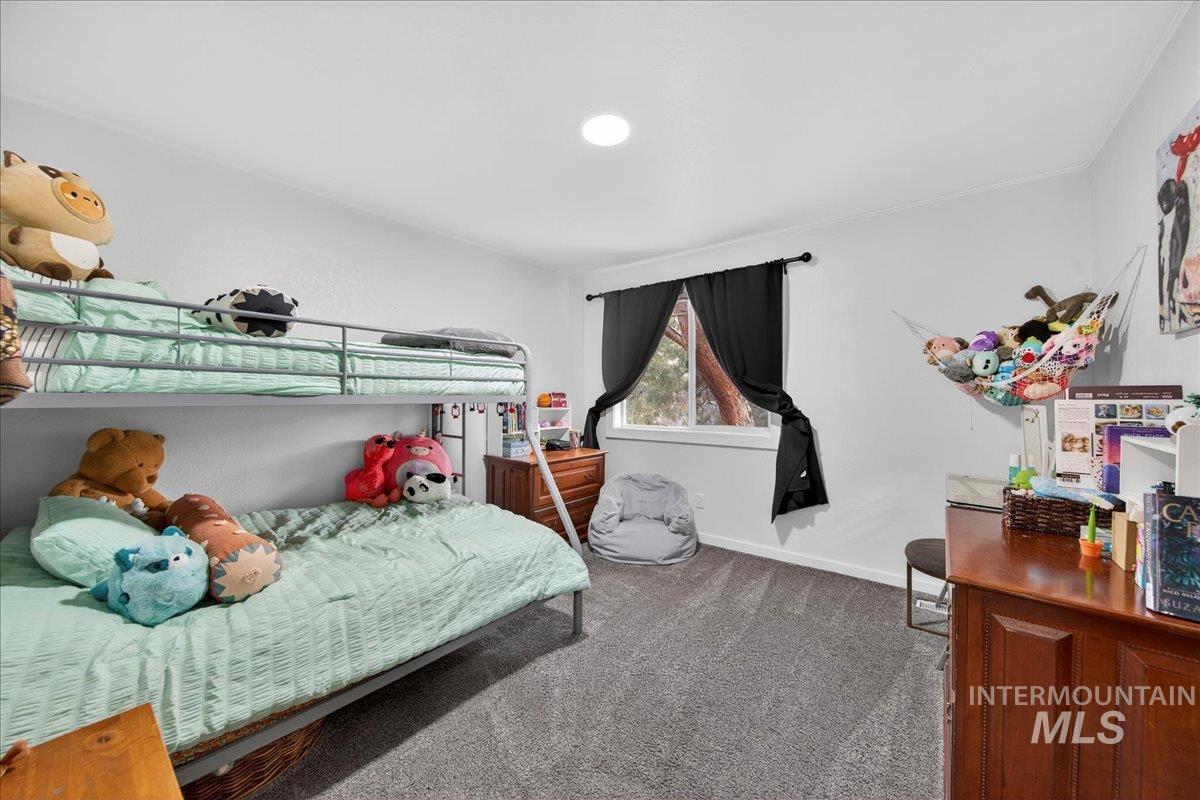 Bedroom featuring dark colored carpet and baseboards