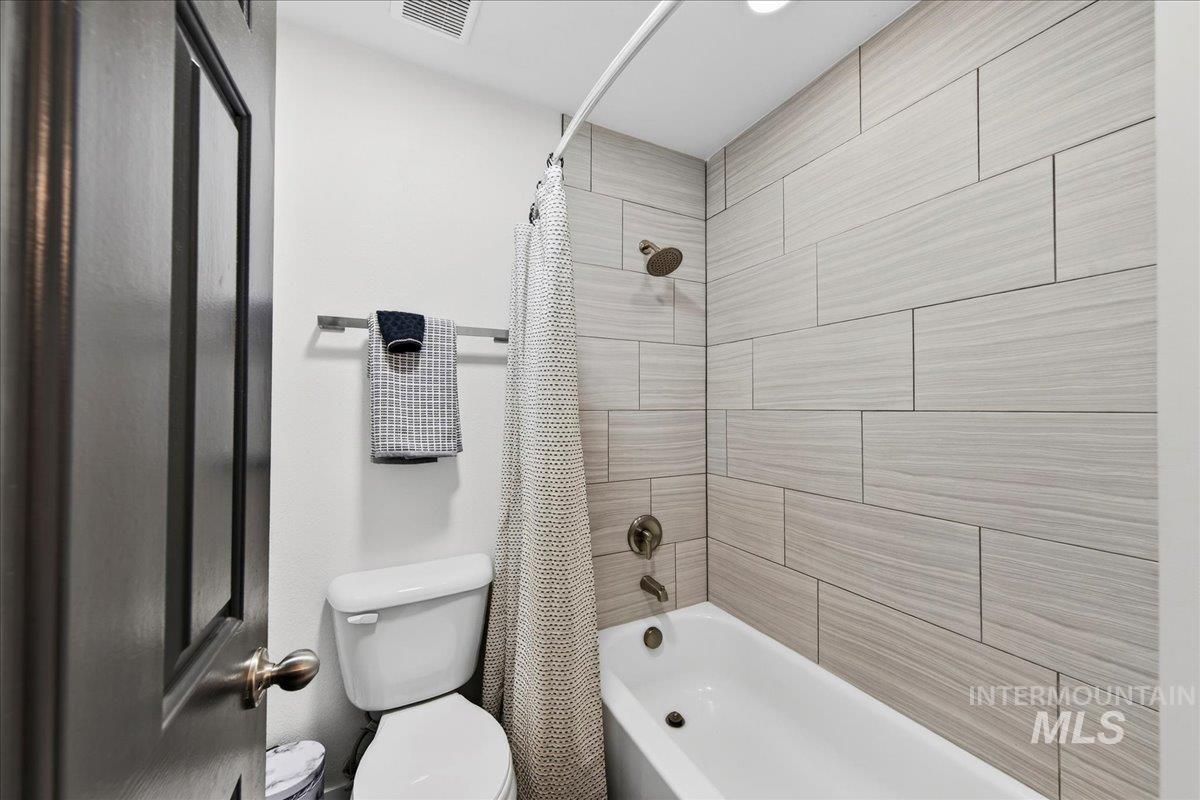 Full bath with shower / bath combination with curtain and toilet