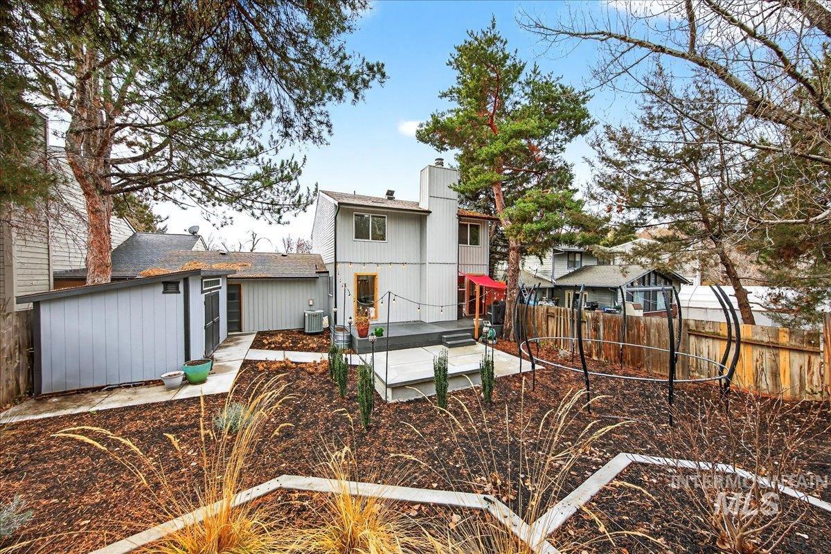 Rear view of house featuring a fenced backyard, a patio area, a chimney, and roof with shingles