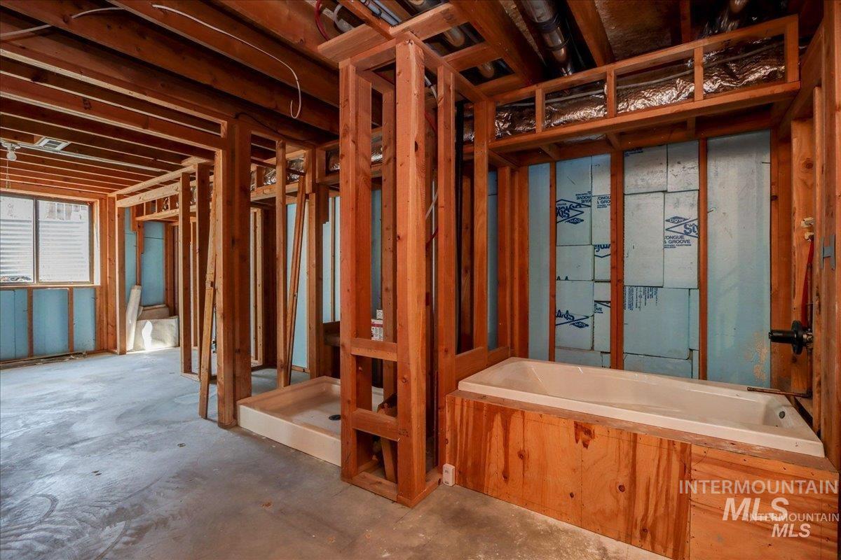 Full bathroom featuring a bath and concrete flooring