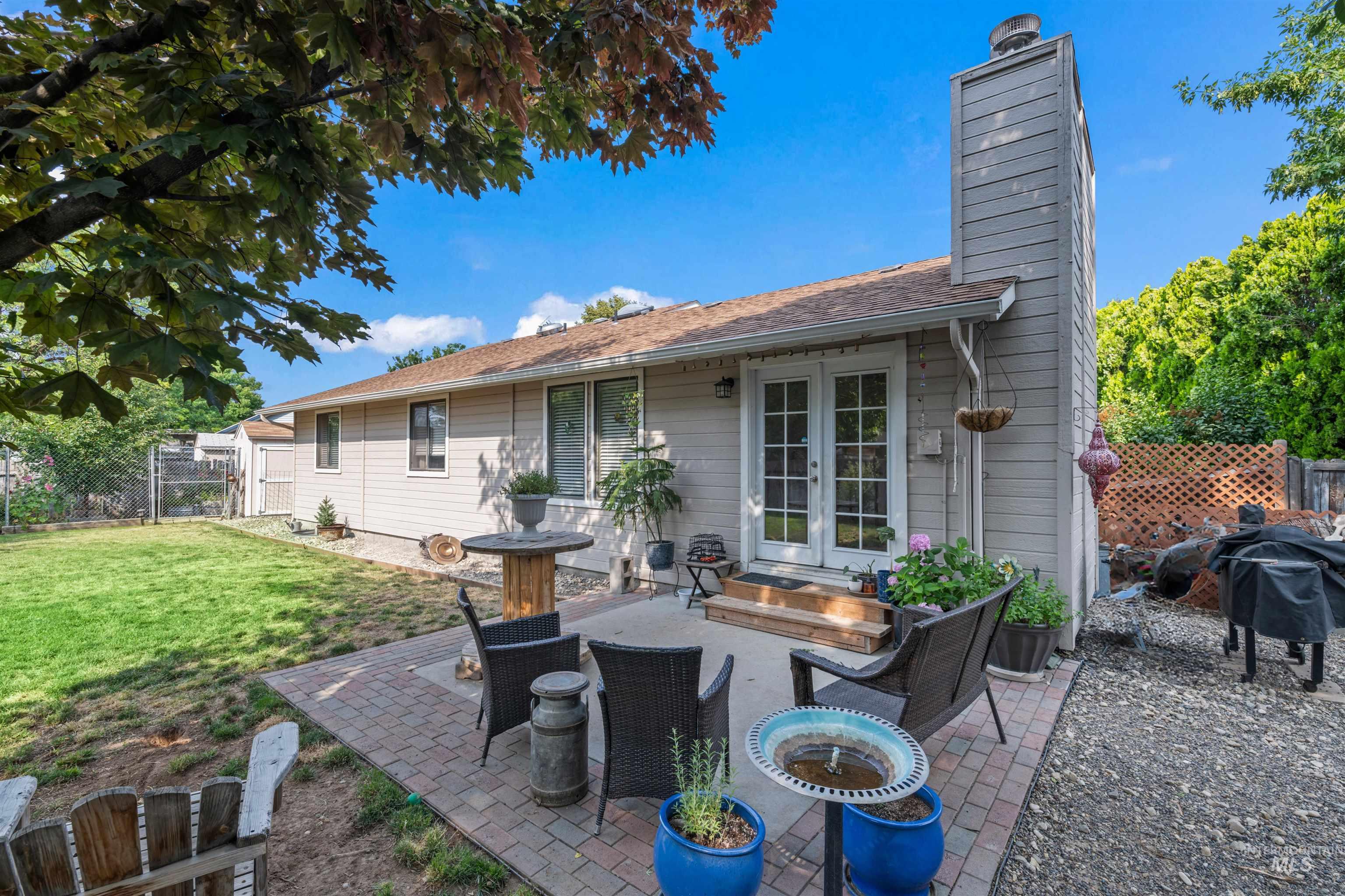 Back of property with a fenced backyard, a patio area, a chimney, french doors, and a gate