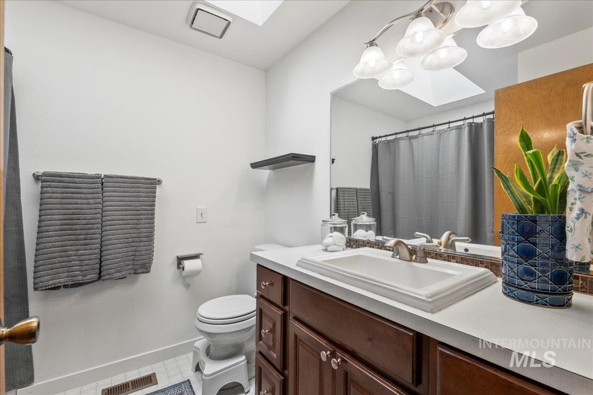 Full bath featuring a skylight and vanity