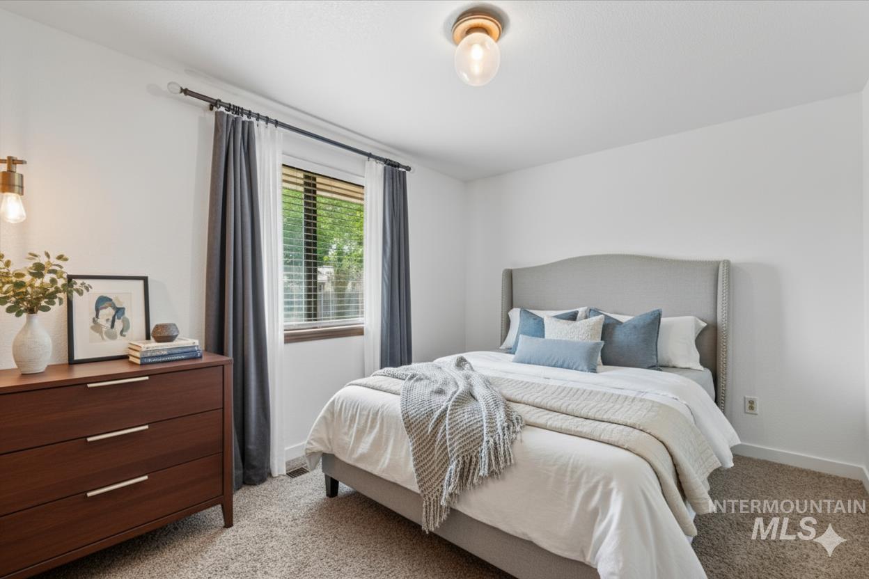 Bedroom featuring light carpet and baseboards