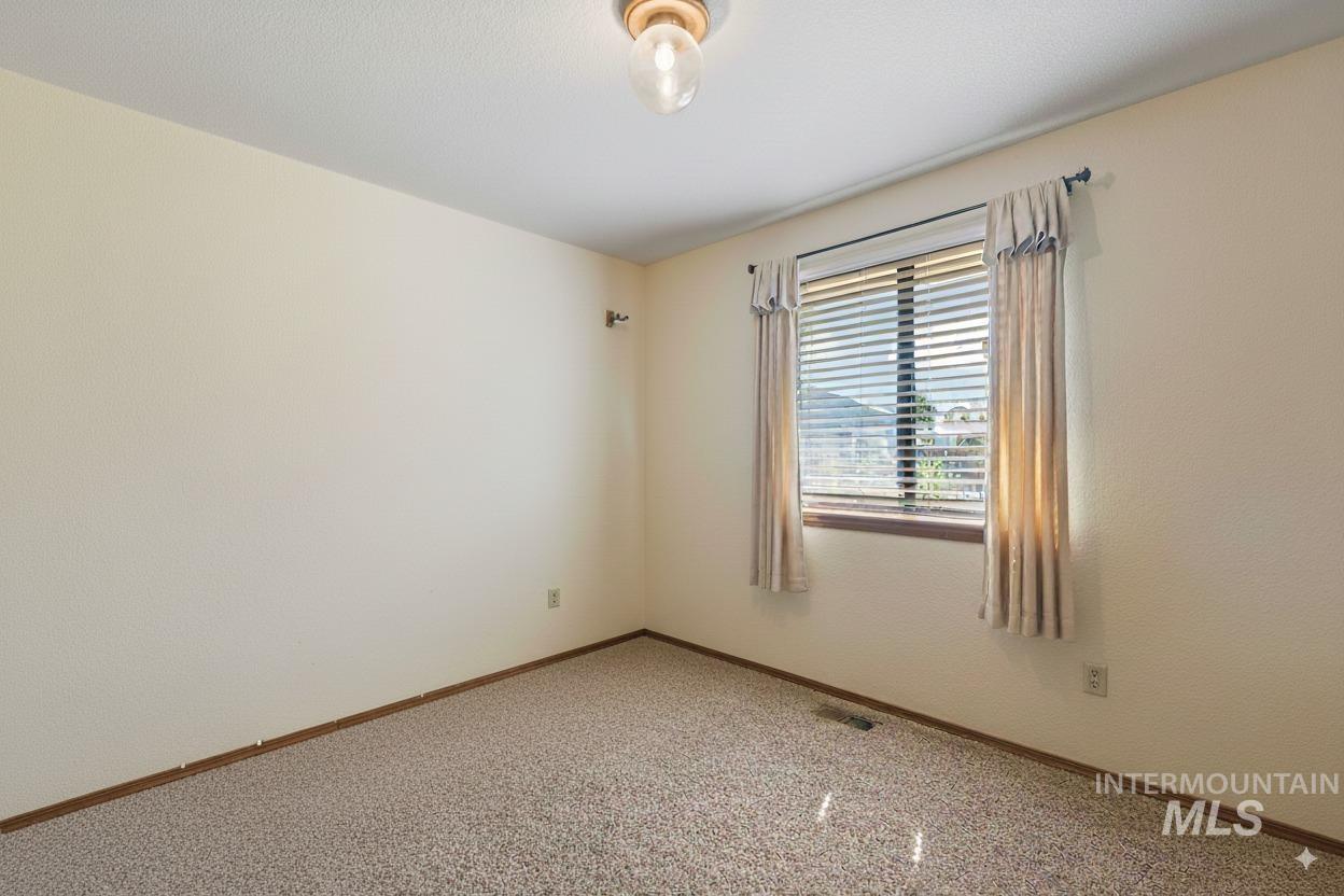 Carpeted spare room with baseboards