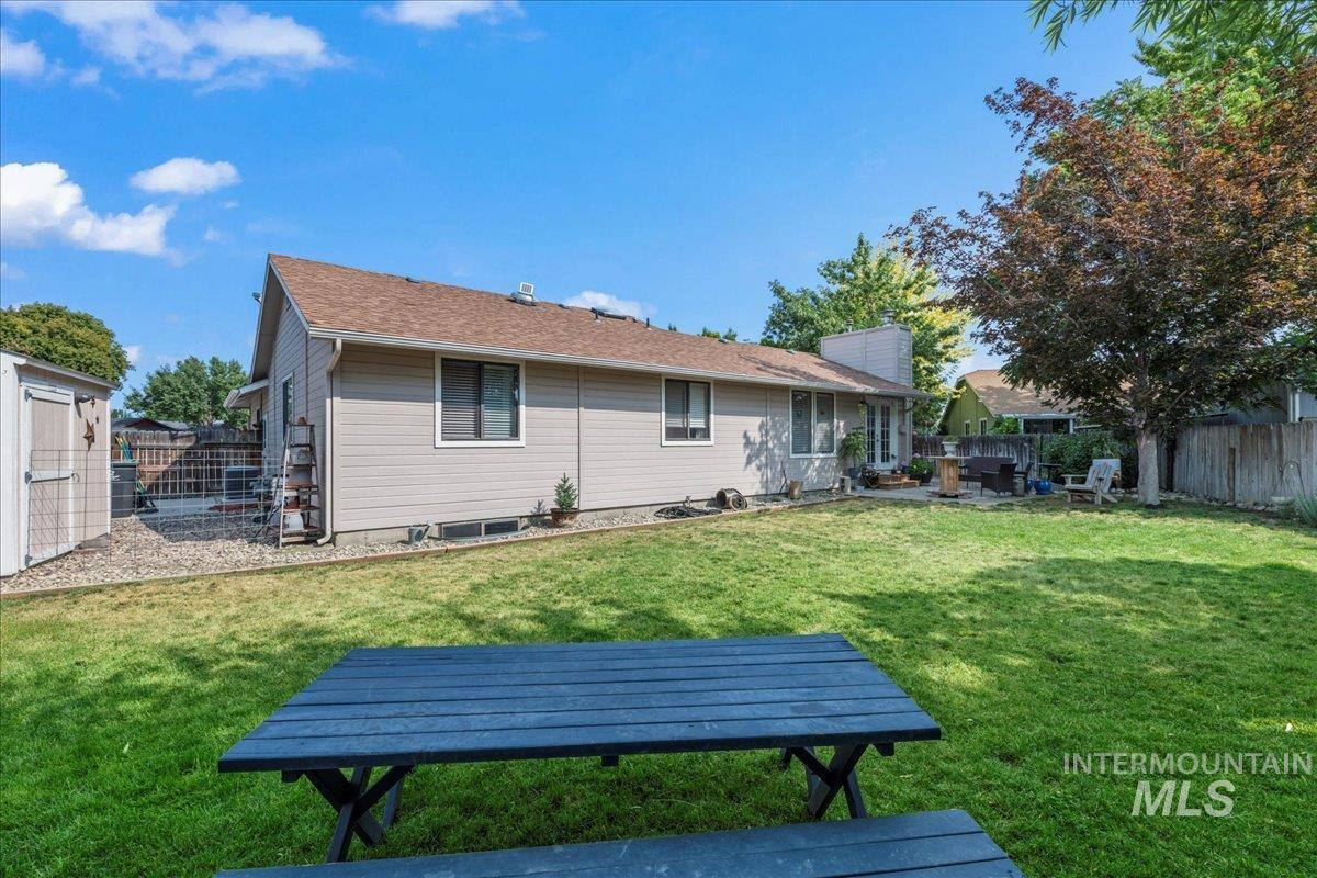 Rear view of house with a fenced backyard and a chimney
