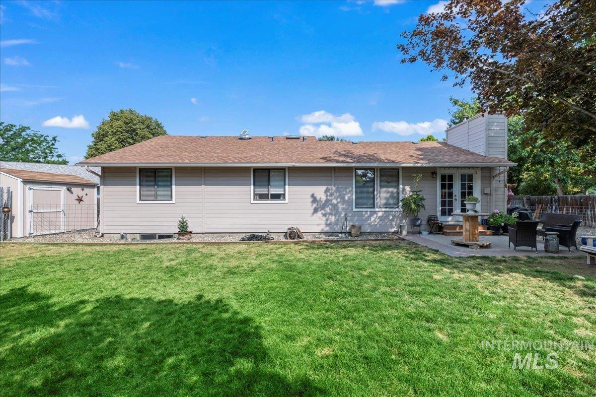 Rear view of property with a patio area, a chimney, and a shed