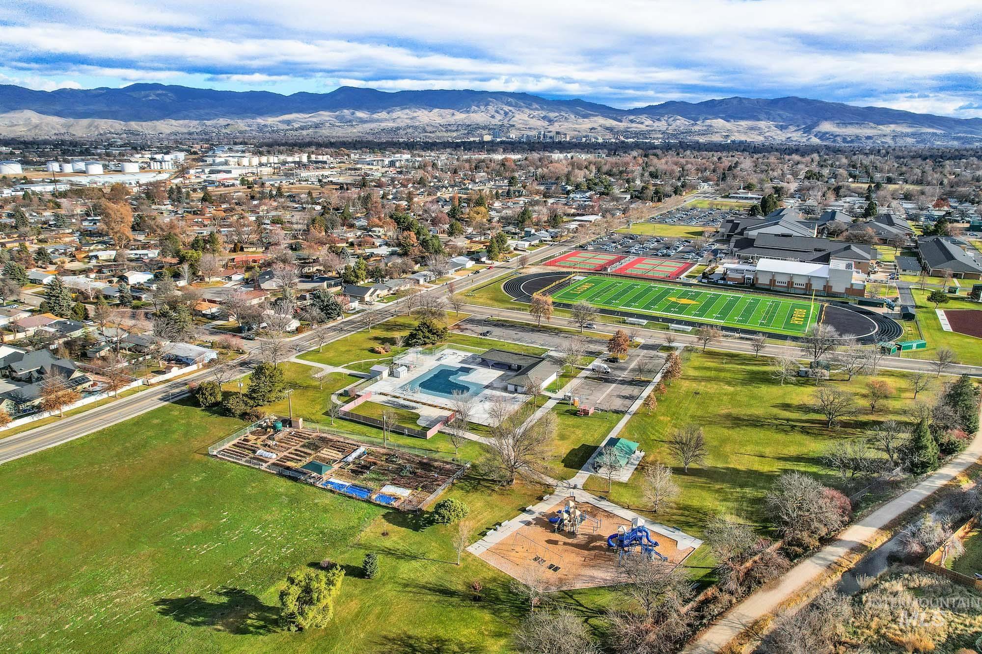 Aerial view of property's location with a mountain backdrop and nearby suburban area