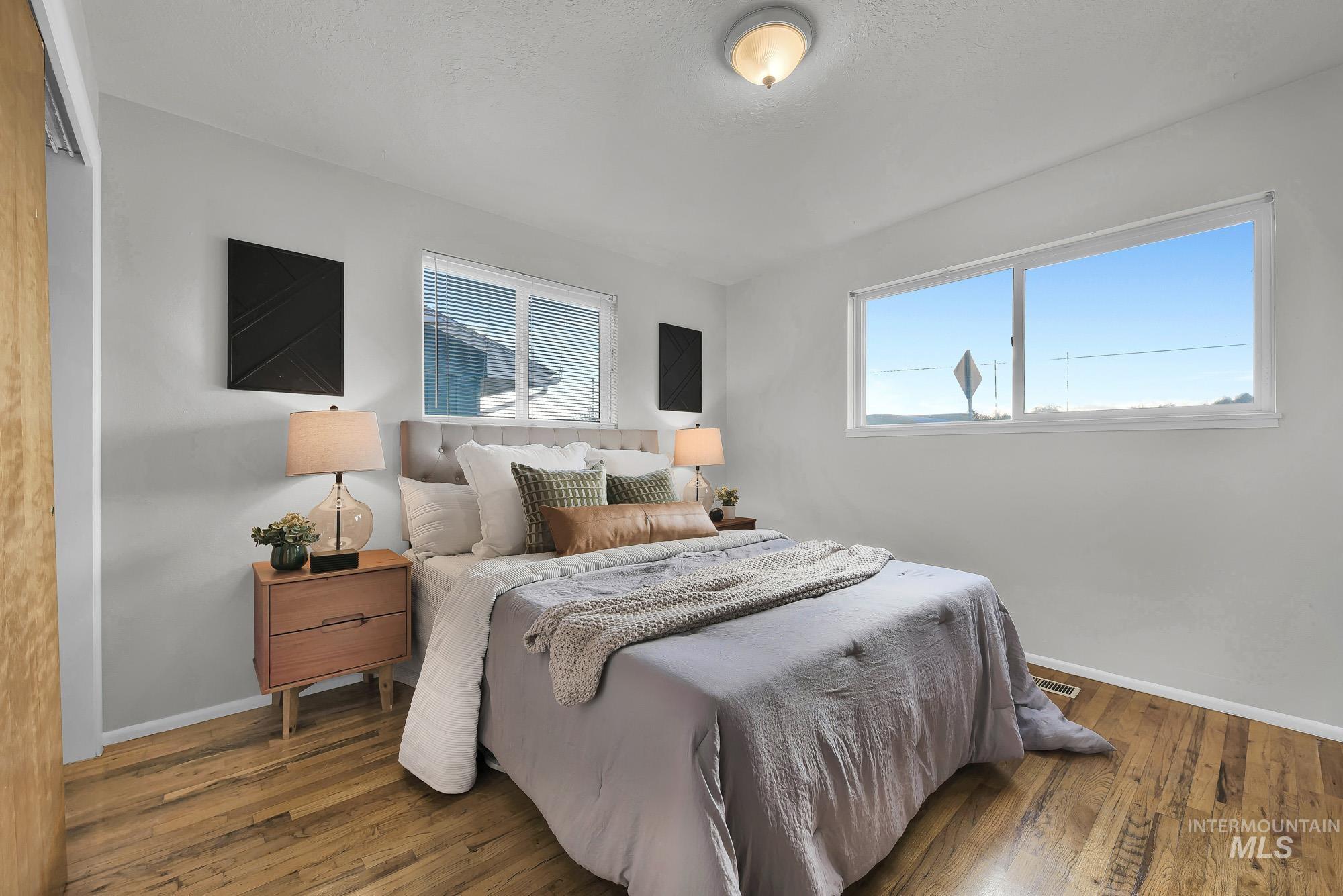 Bedroom with multiple windows and hardwood / wood-style floors