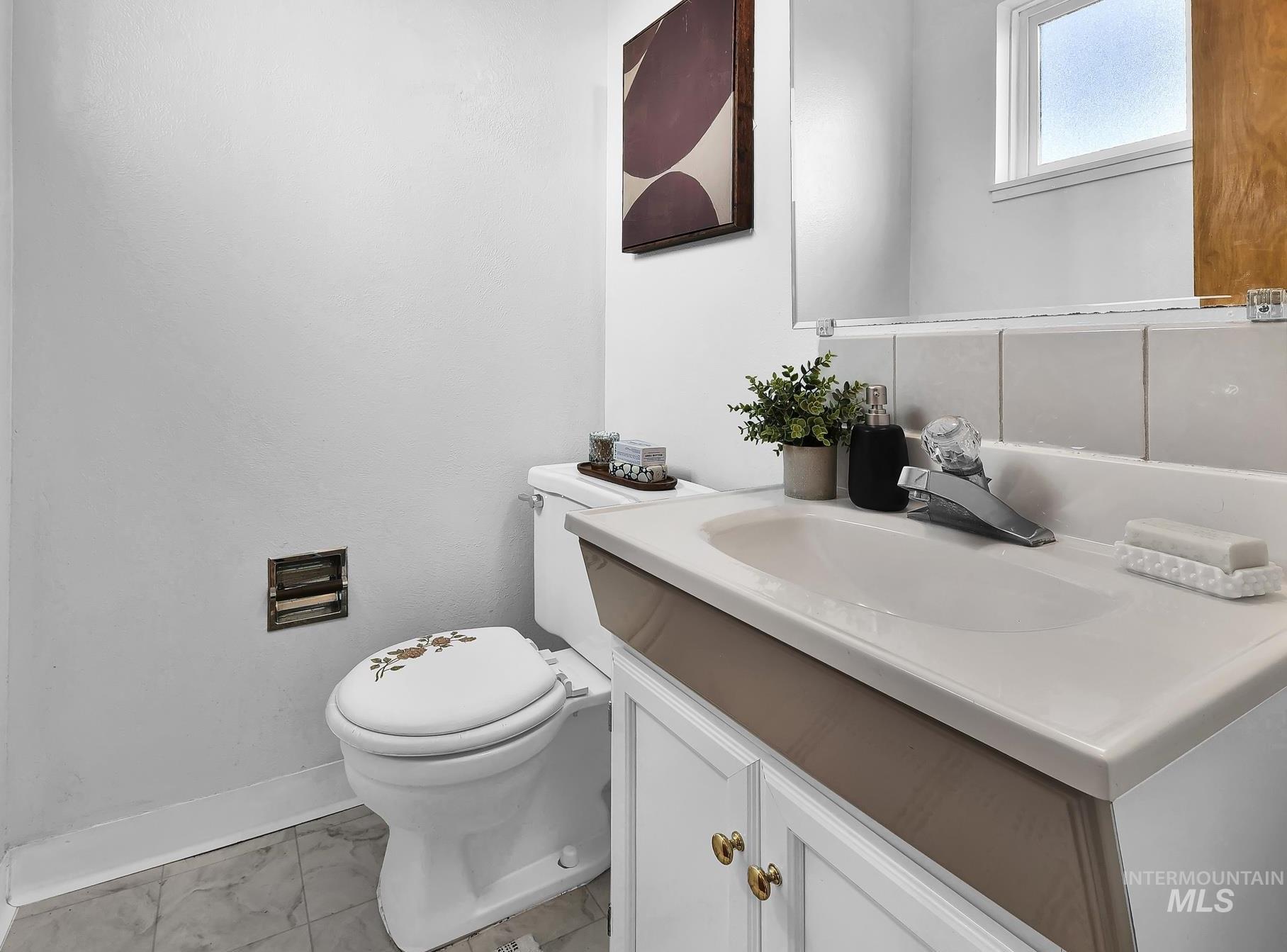 Bathroom with vanity and light marble finish flooring