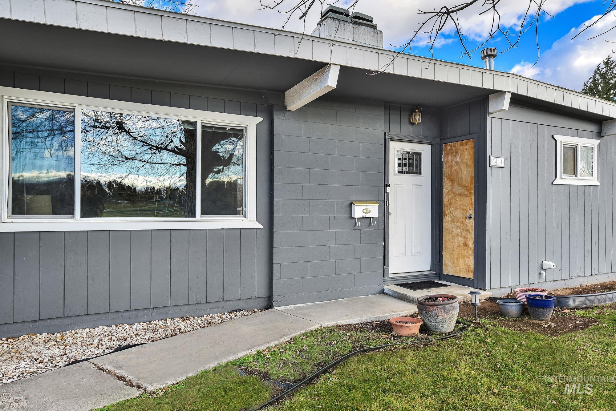 Doorway to property with a chimney and concrete block siding