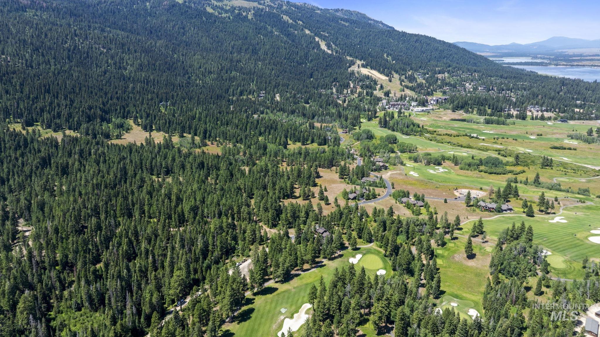 Aerial overview of property's location with a golf course and a water and mountain view