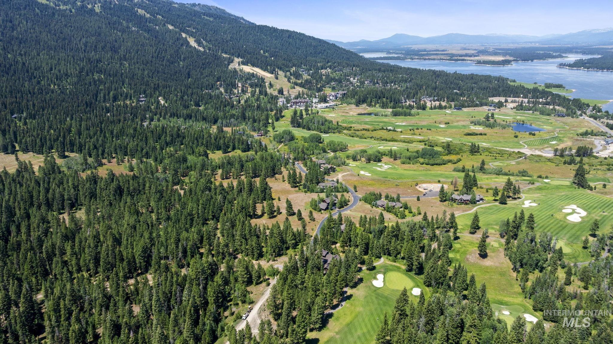 Aerial view of property and surrounding area with a water and mountain view and a golf club