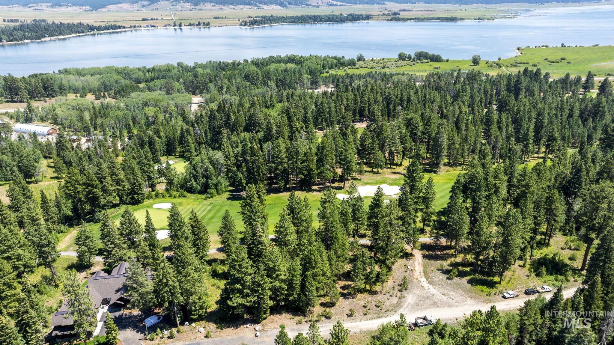 Aerial overview of property's location featuring a large body of water and a local golf course