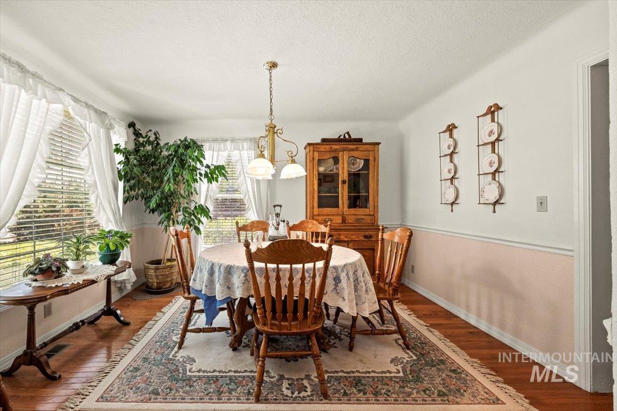 Dining space featuring wood finished floors and a textured ceiling