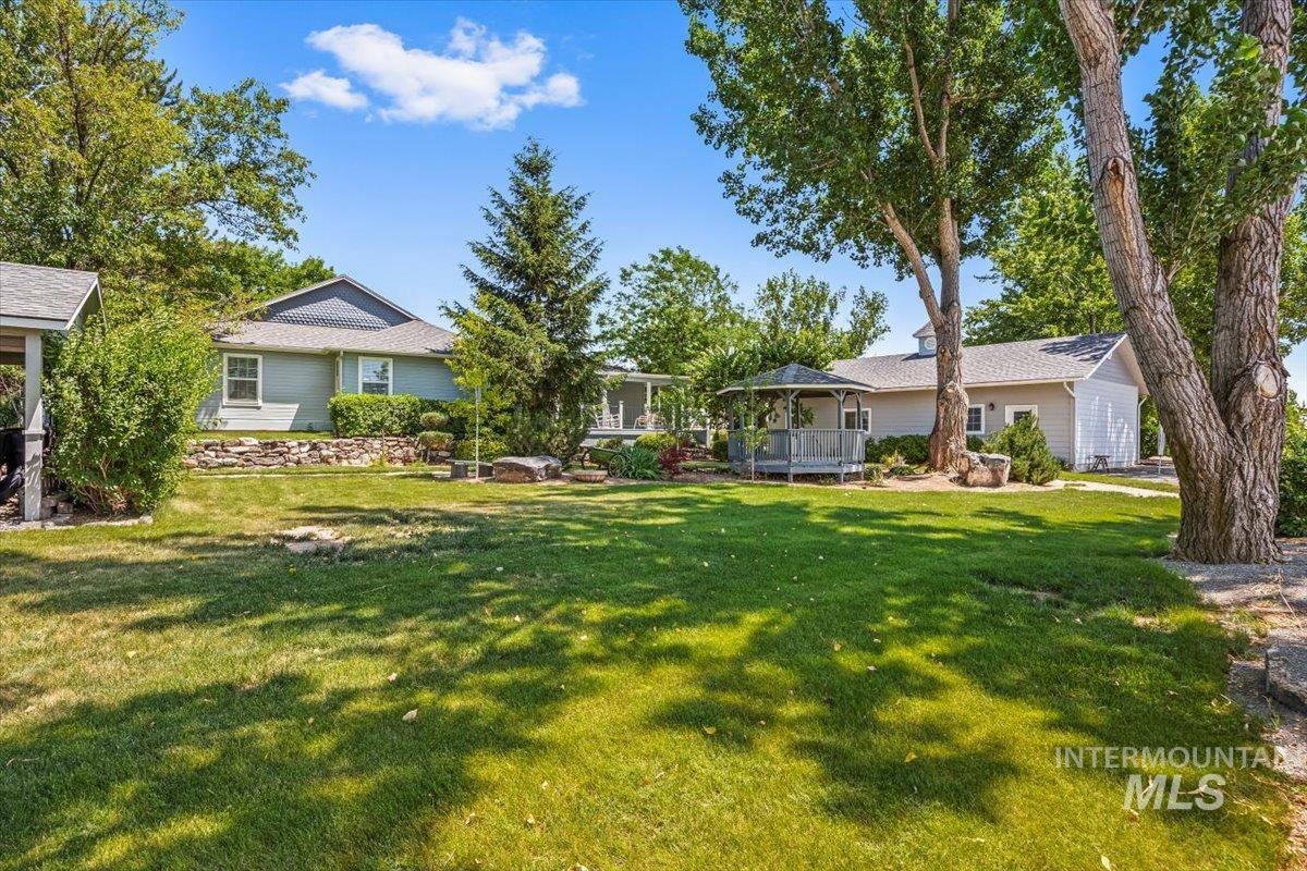 View of grassy yard featuring a gazebo and a wooden deck