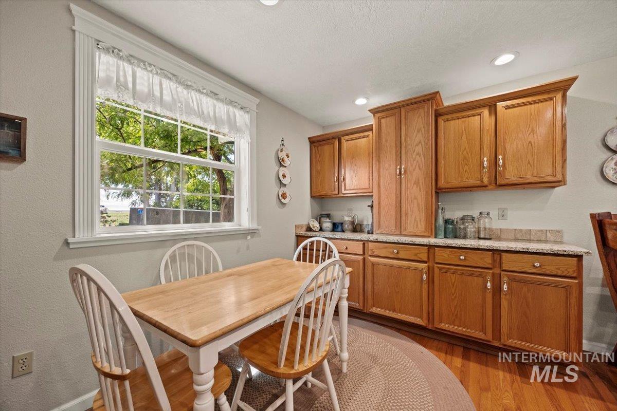Kitchen with brown cabinets, light wood-style flooring, recessed lighting, and a textured ceiling