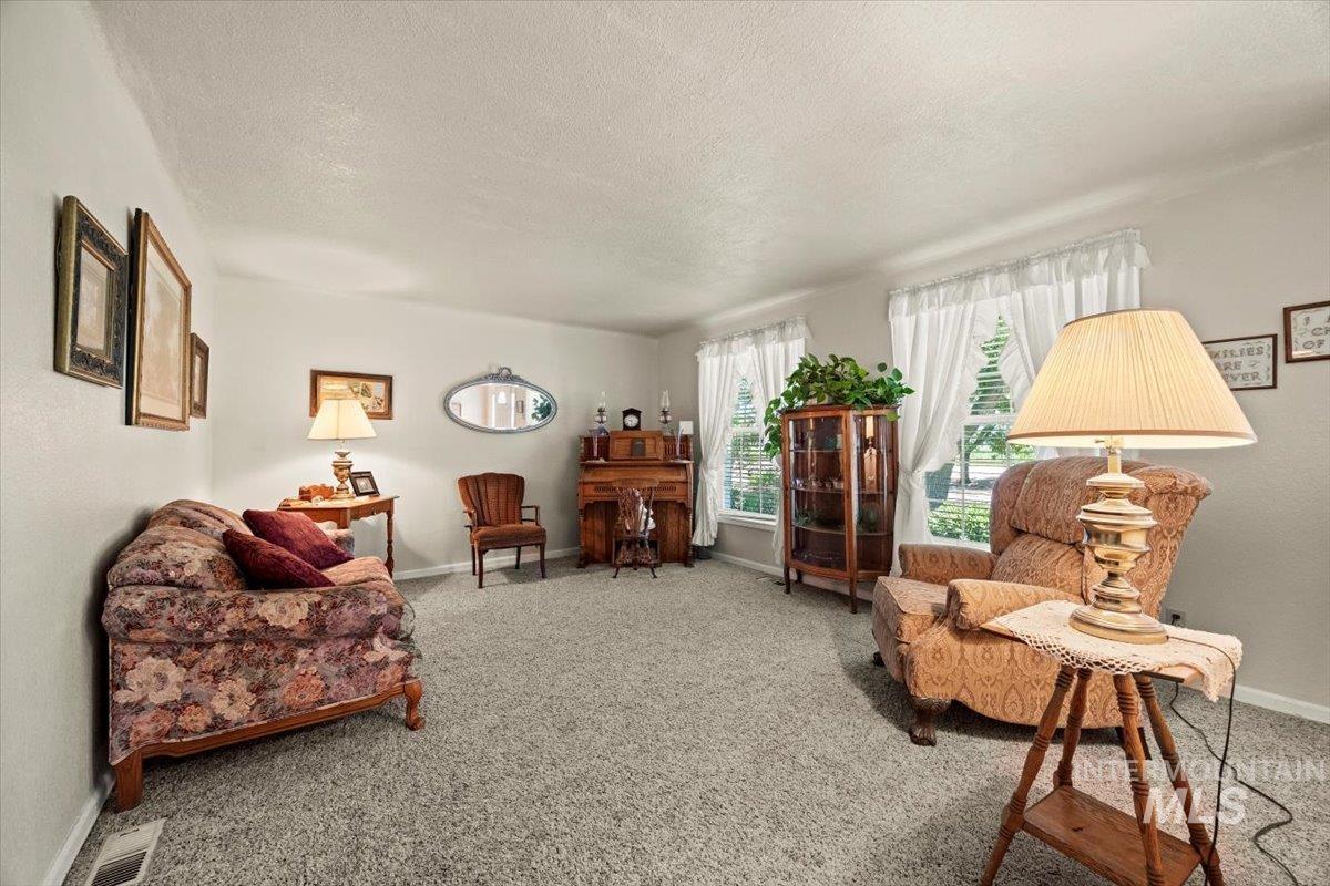 Living room with a textured ceiling and carpet flooring