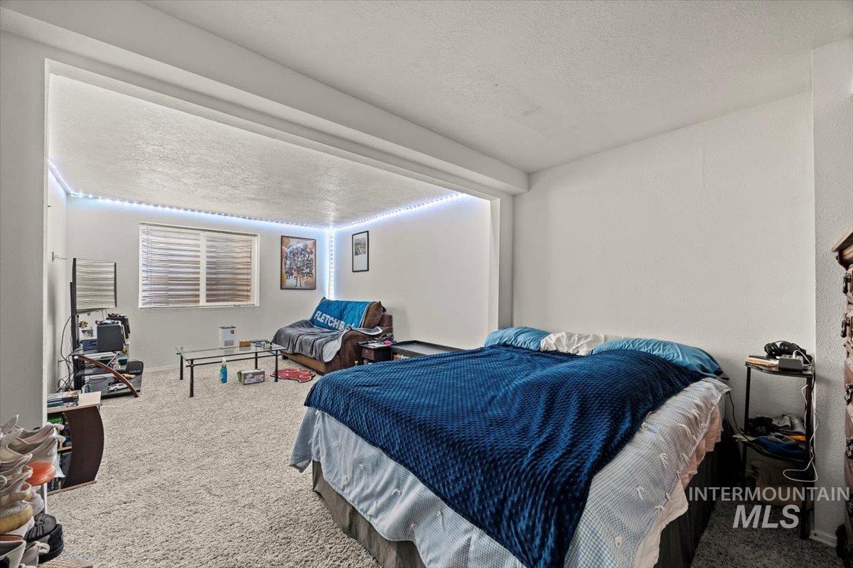 Bedroom featuring carpet flooring and a textured ceiling