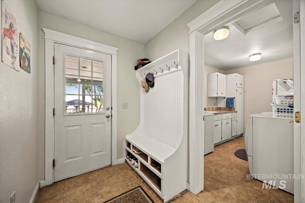 Mudroom featuring washer / clothes dryer, attic access, and light floors