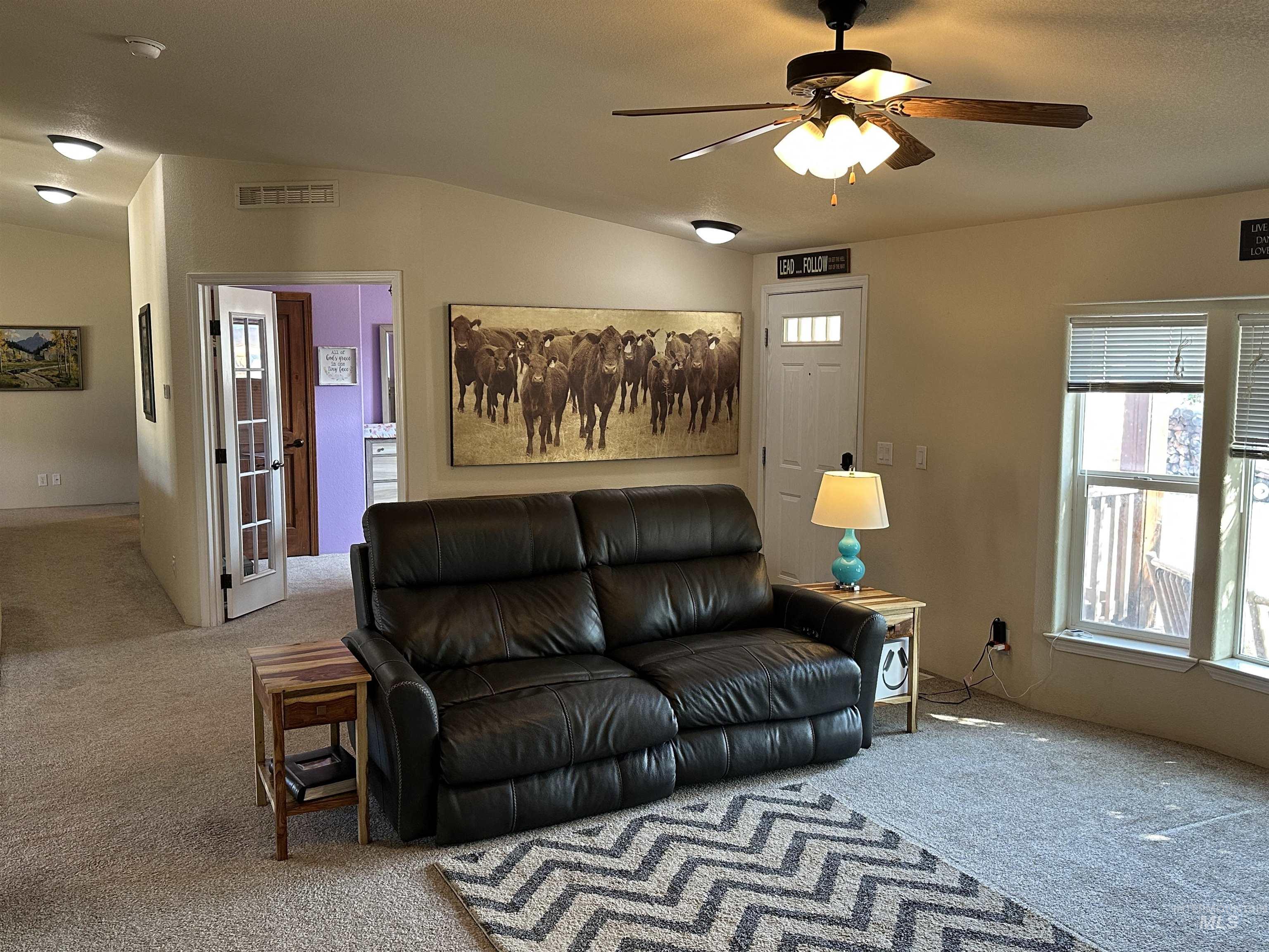 Living area featuring carpet and ceiling fan