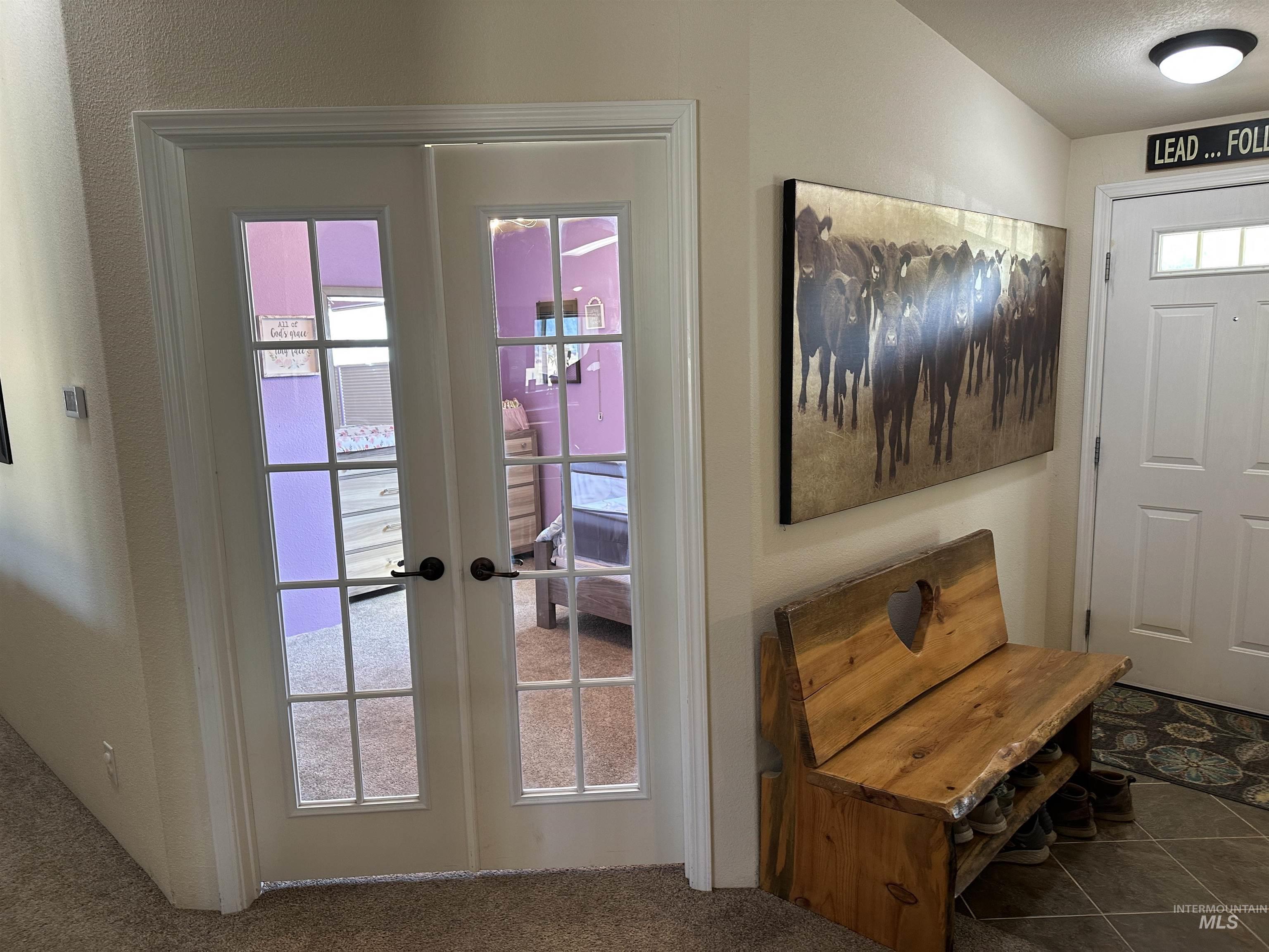 Doorway with french doors, carpet, and tile patterned flooring