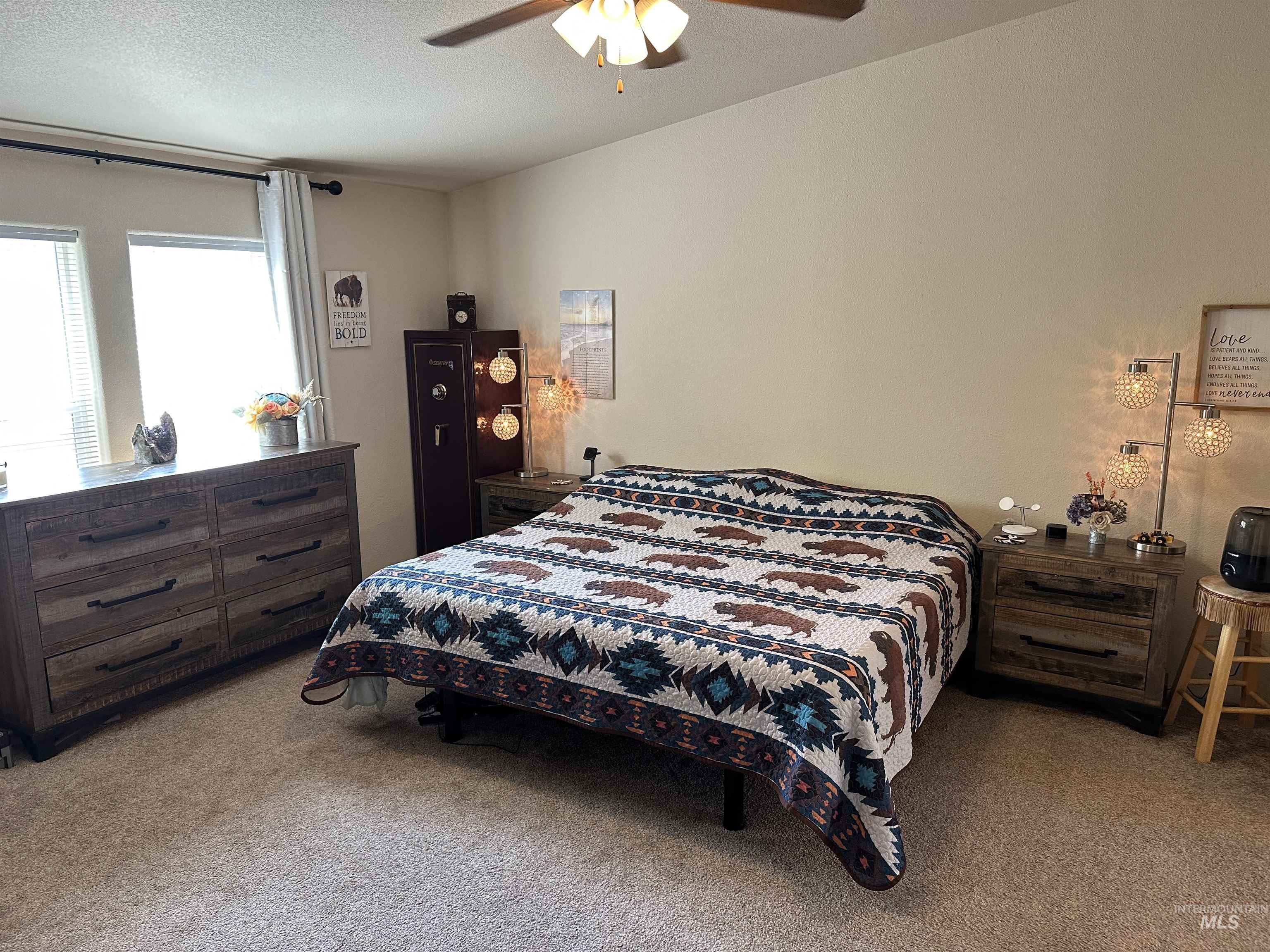 Bedroom with carpet flooring, ceiling fan, and a textured ceiling