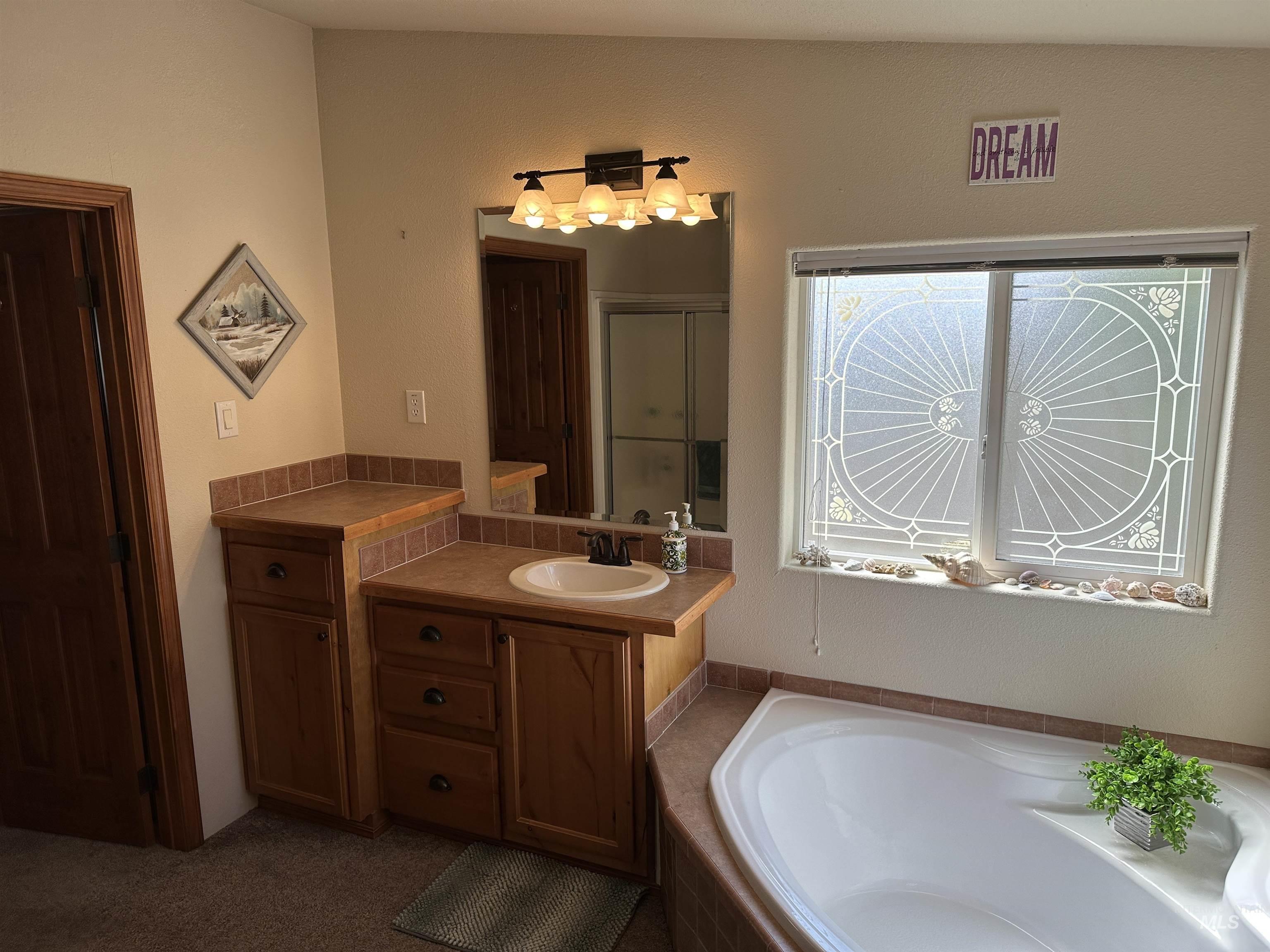 Full bathroom featuring vanity, a bath, and a stall shower