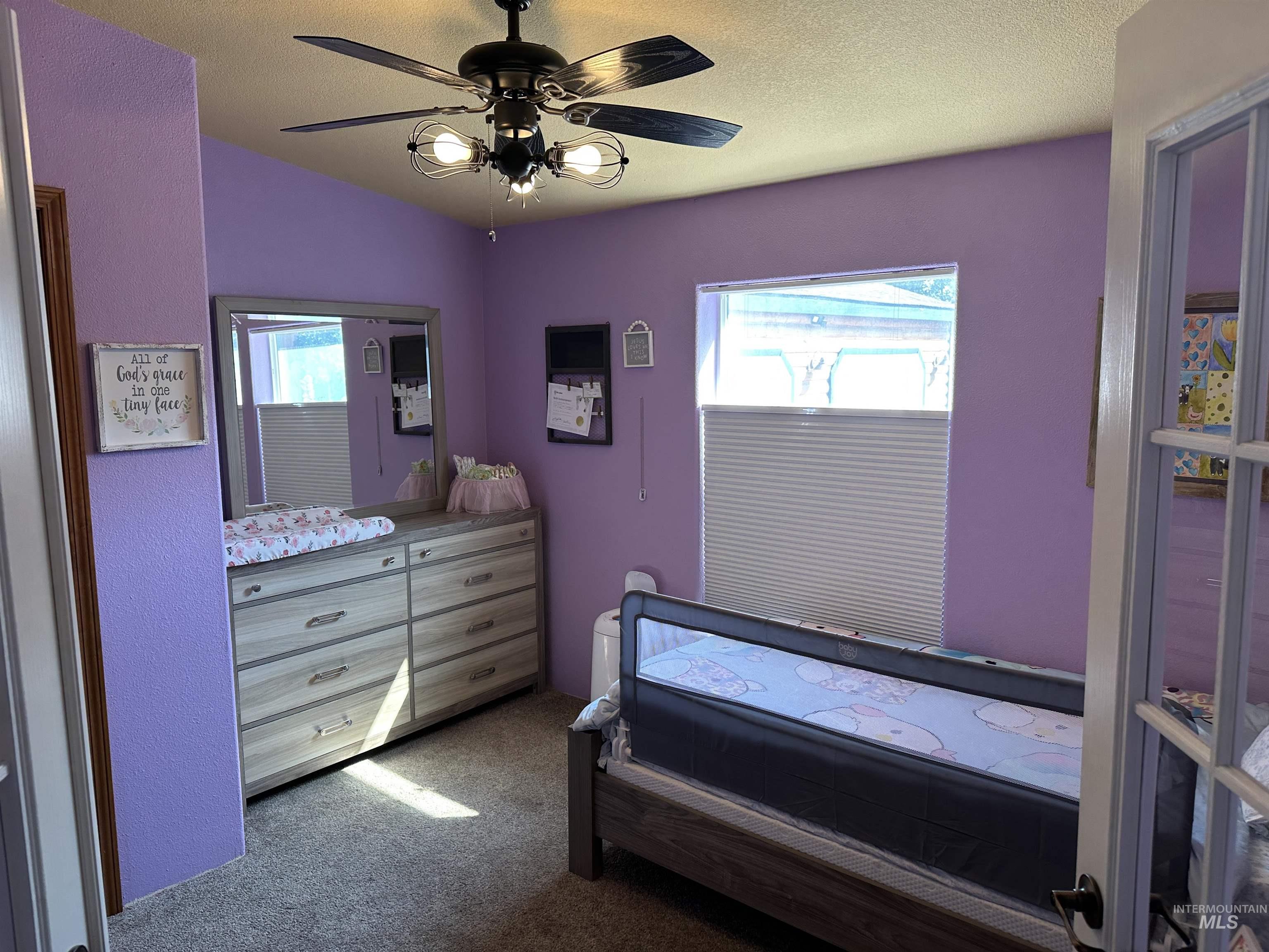 Bedroom featuring dark colored carpet, ceiling fan, and a textured ceiling