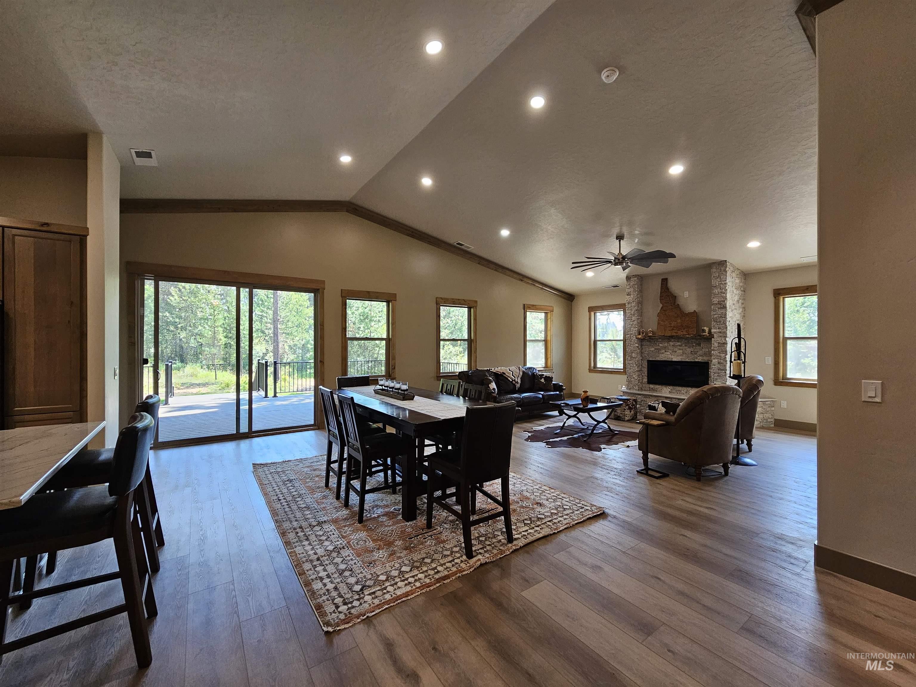 Dining space featuring vaulted ceiling and vinyl plank flooring