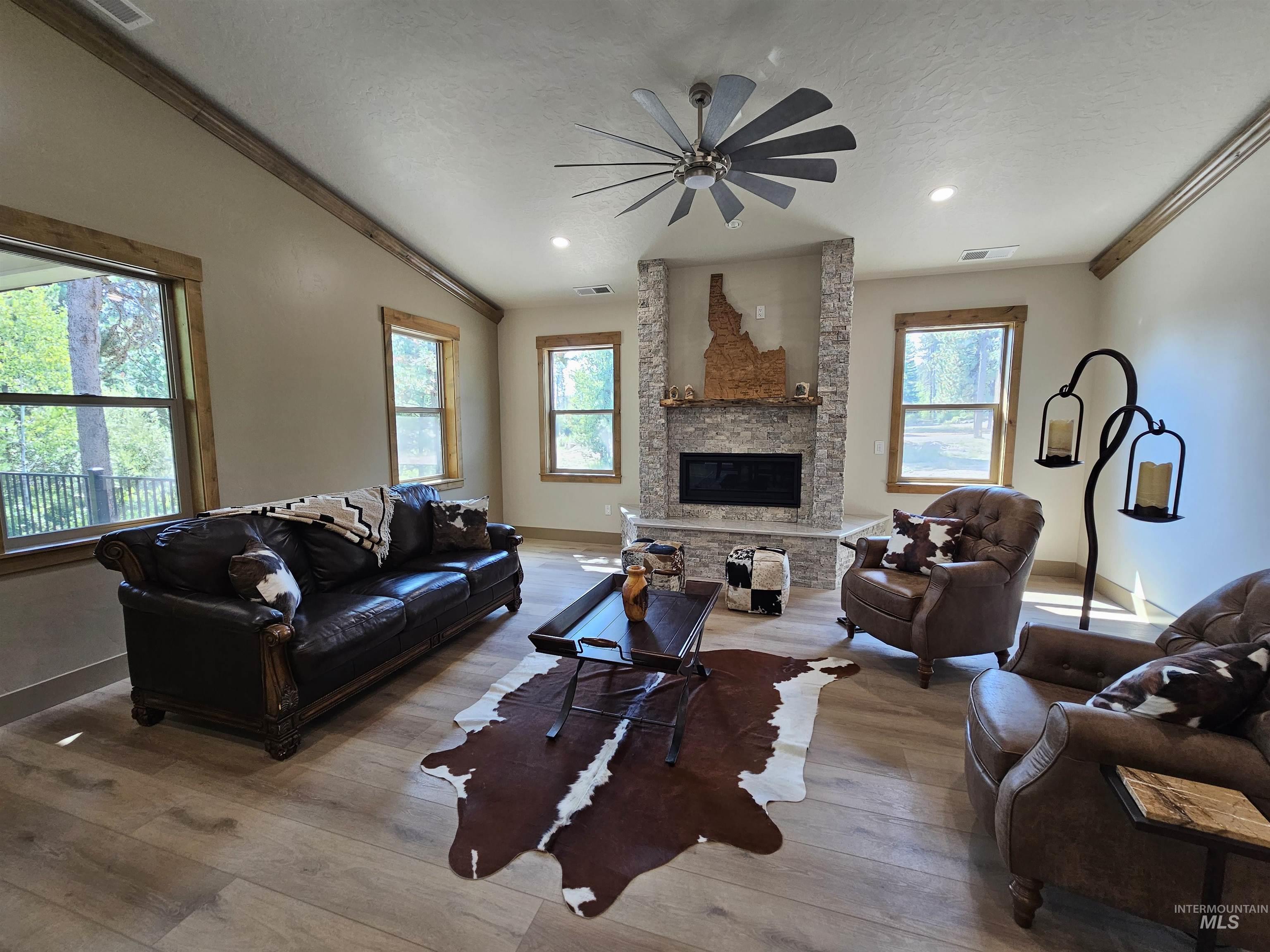 Living room has vaulted ceilings and plenty of windows.
