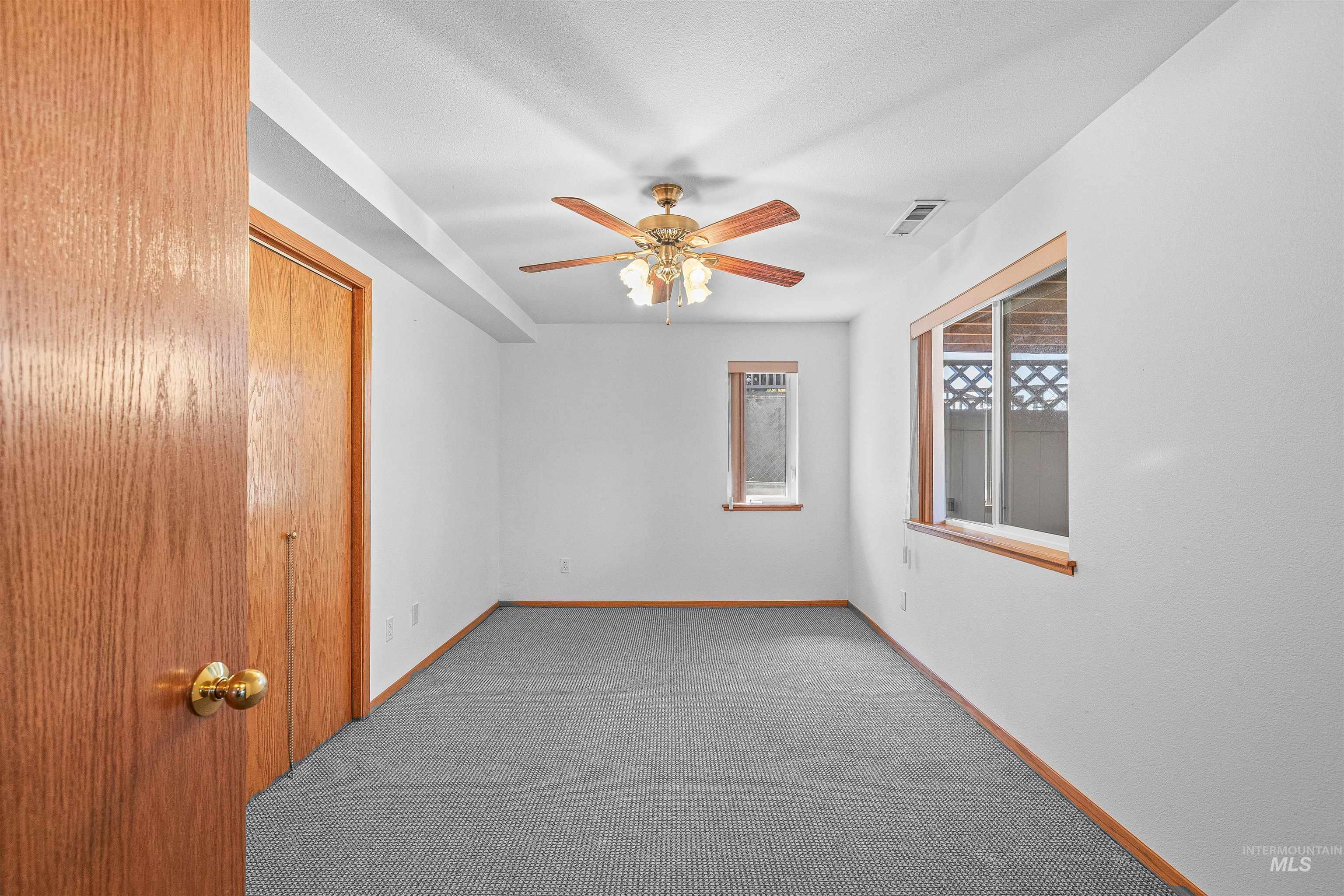 Spare room featuring a ceiling fan and carpet floors