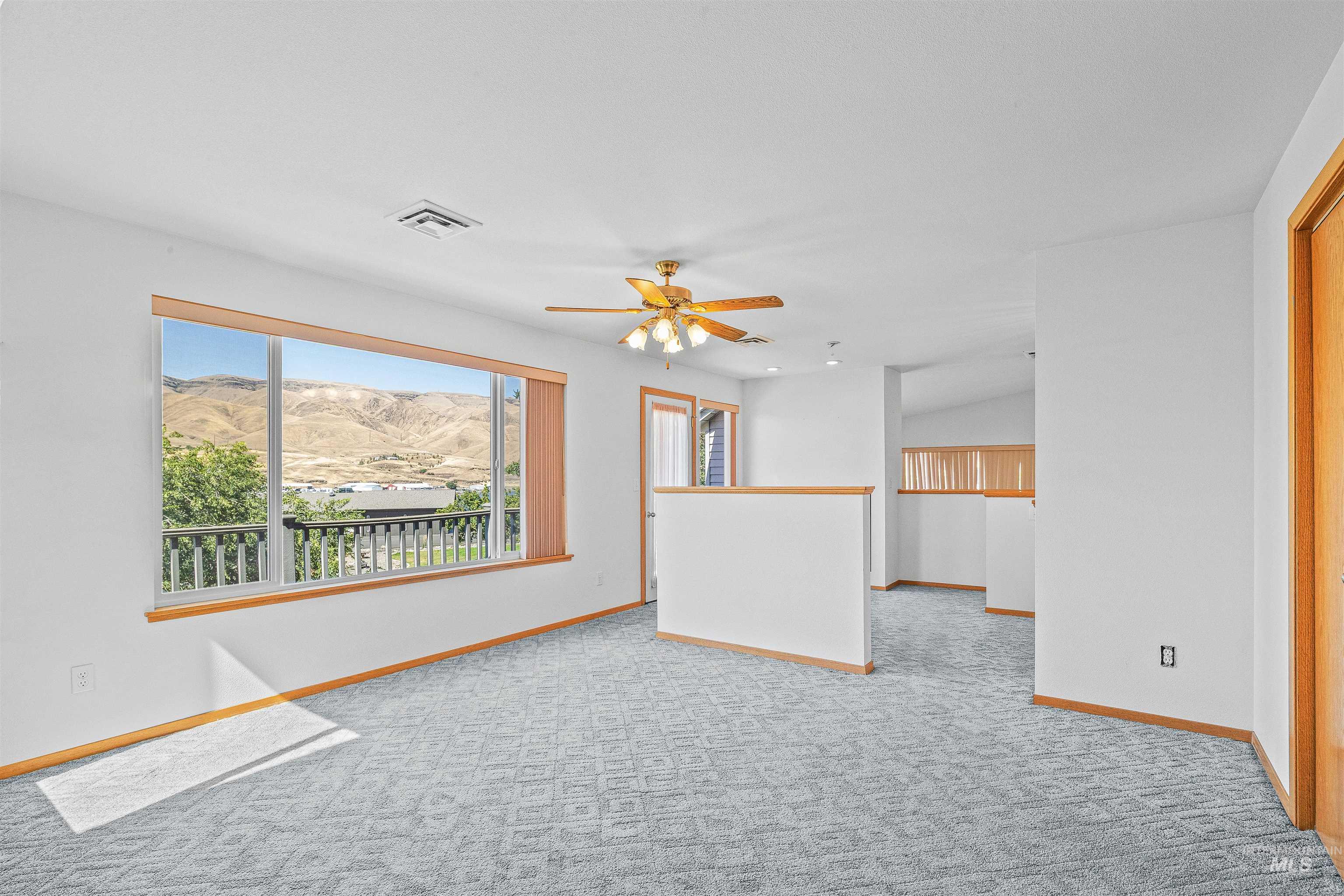 Unfurnished living room with carpet, a mountain view, and ceiling fan