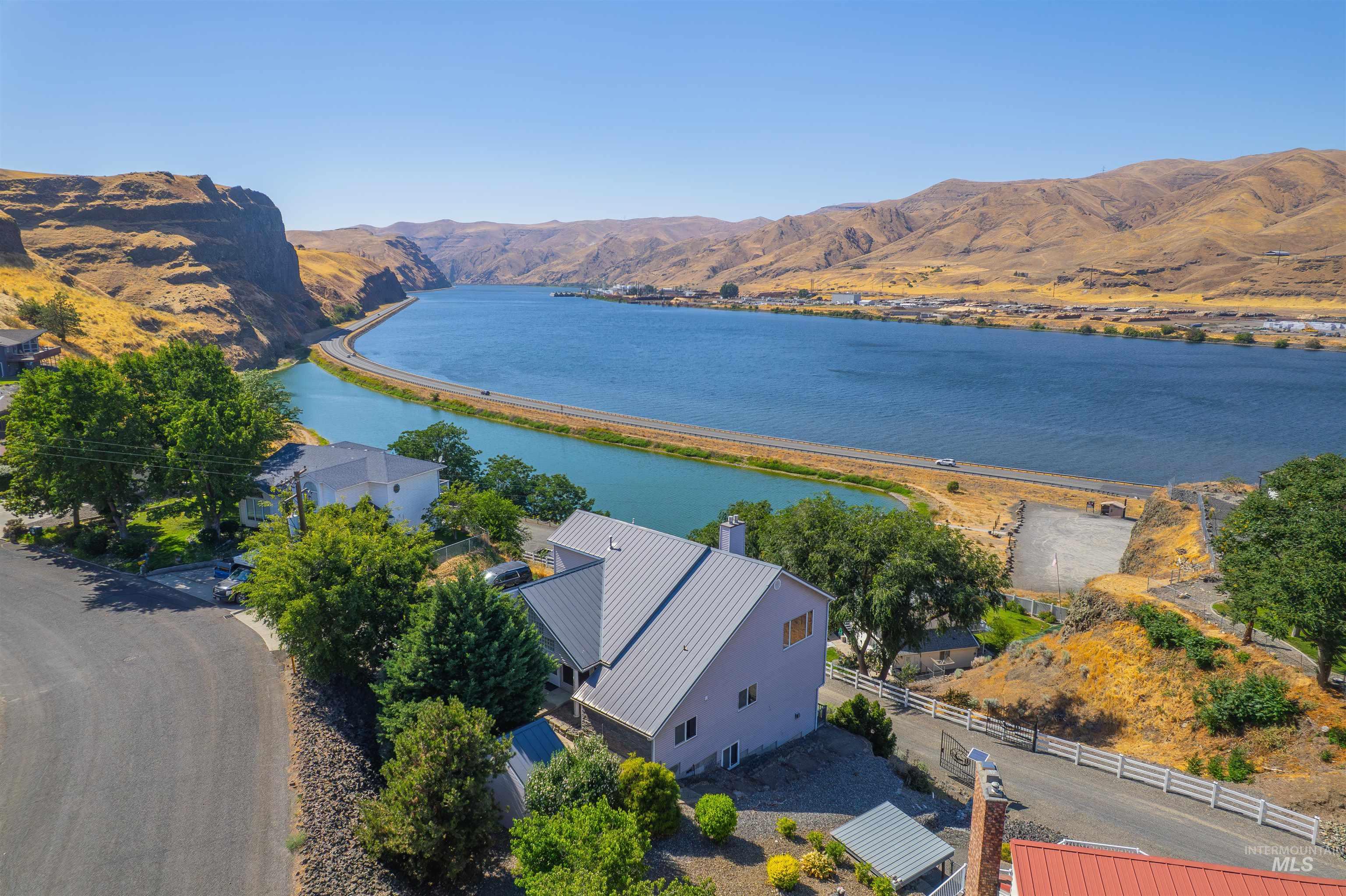 Aerial view of property and surrounding area featuring a water and mountain view